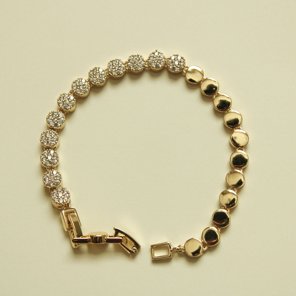 Gold and pavé tennis bracelet with alternating round stone stations and polished disc beads.