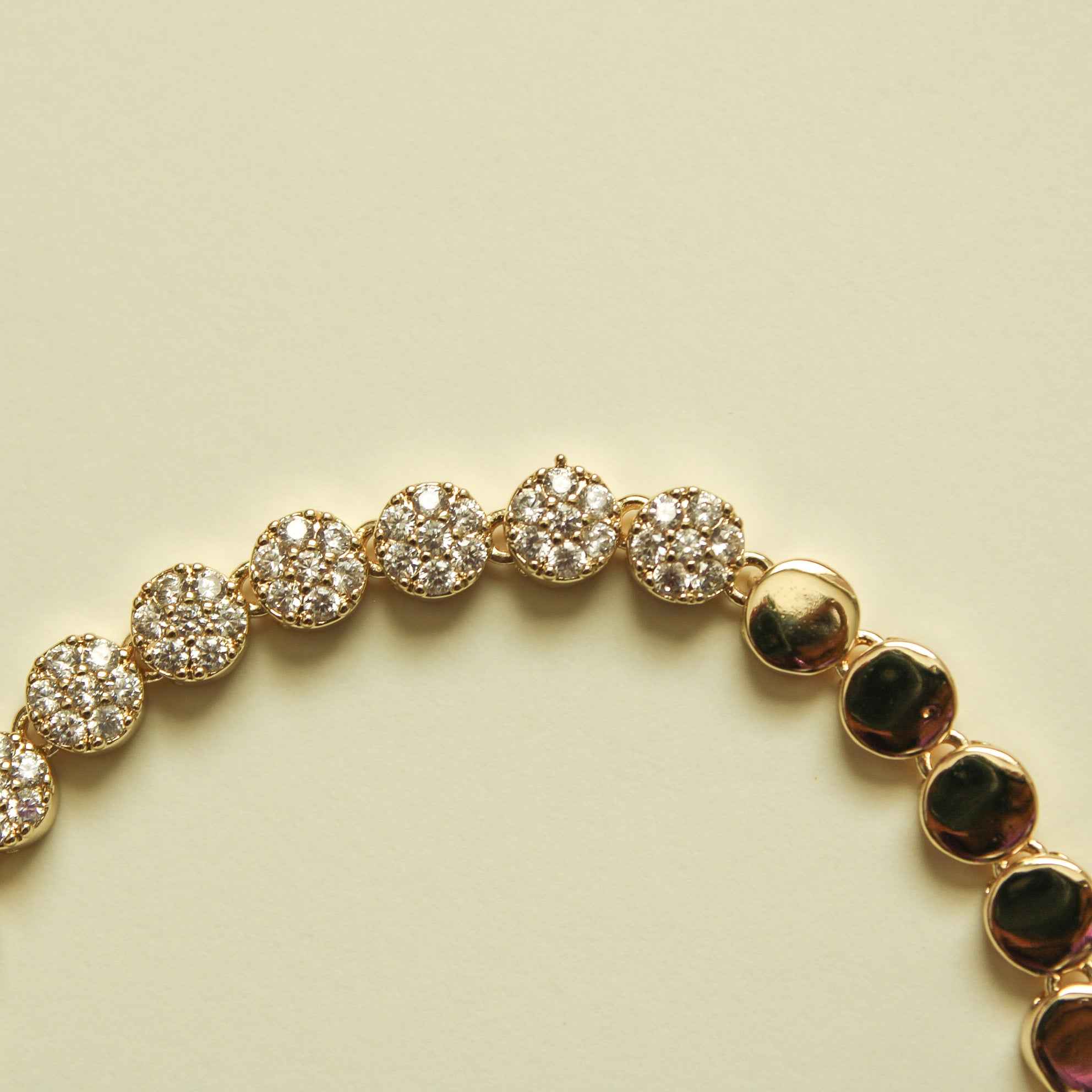Gold and pavé round-disc tennis bracelet, alternating stone clusters and polished disc links.