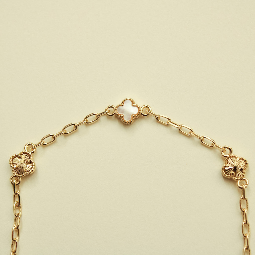 Gold bracelet close view of clover charms on a linked chain