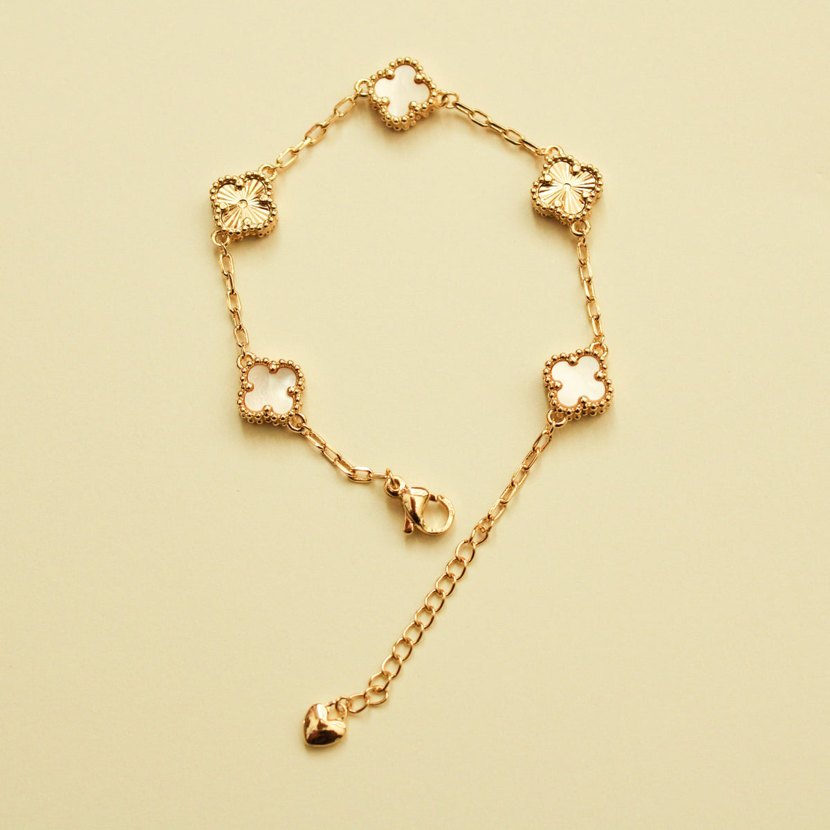 Gold clover bracelet with mother-of-pearl inlays and heart drop charm