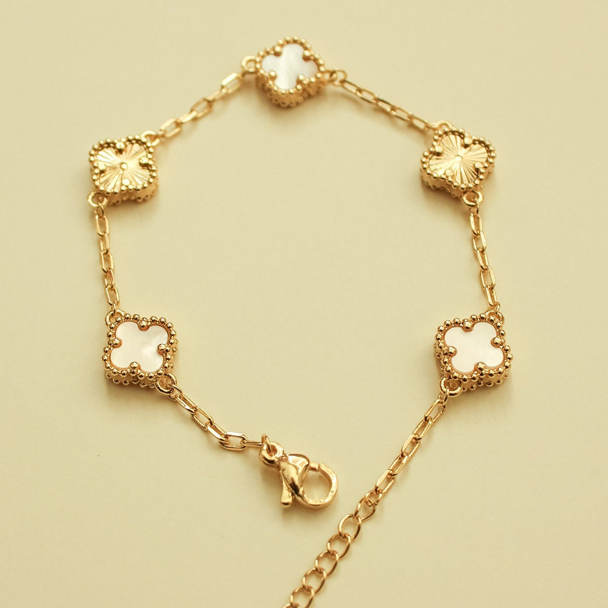 Gold-tone bracelet with mother-of-pearl clover charms and chain links