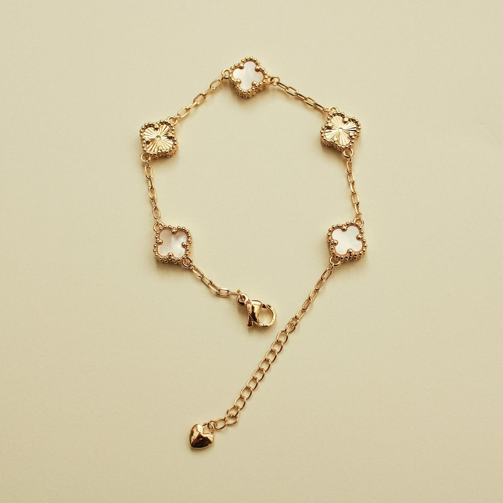 Gold bracelet with clover charms and mother-of-pearl inlays, heart drop detail