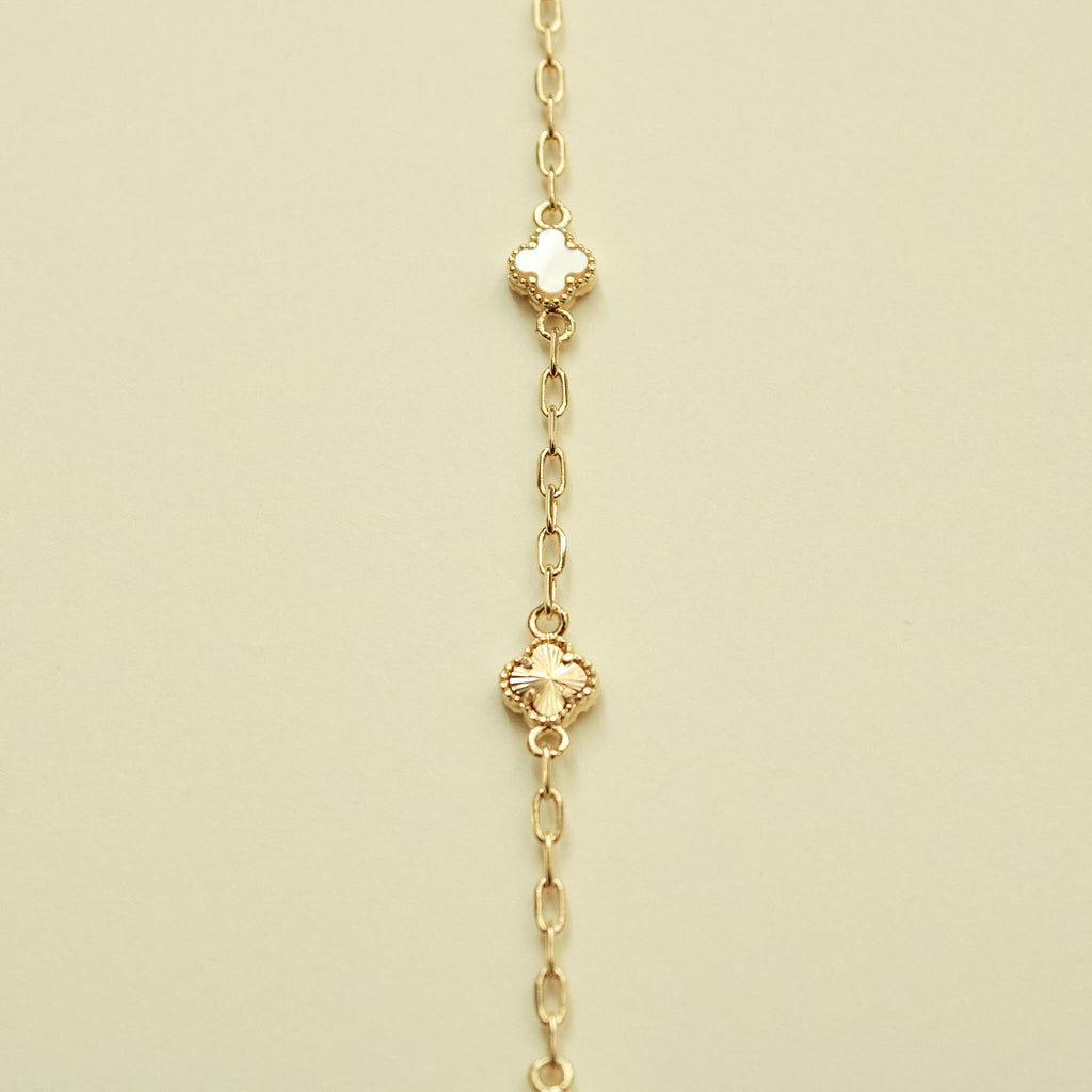 Gold bracelet with clover-shaped charms and mother-of-pearl inlays, vertical view
