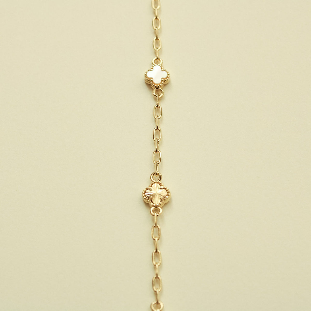 Gold bracelet with clover-shaped charms and mother-of-pearl inlays, vertical view
