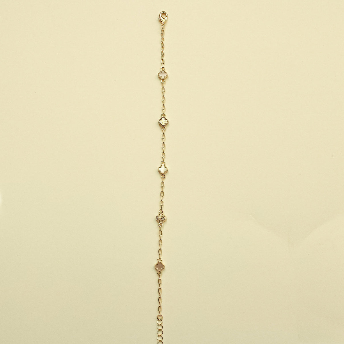 Gold chain bracelet with small clover charms and mother-of-pearl inlays, top loop