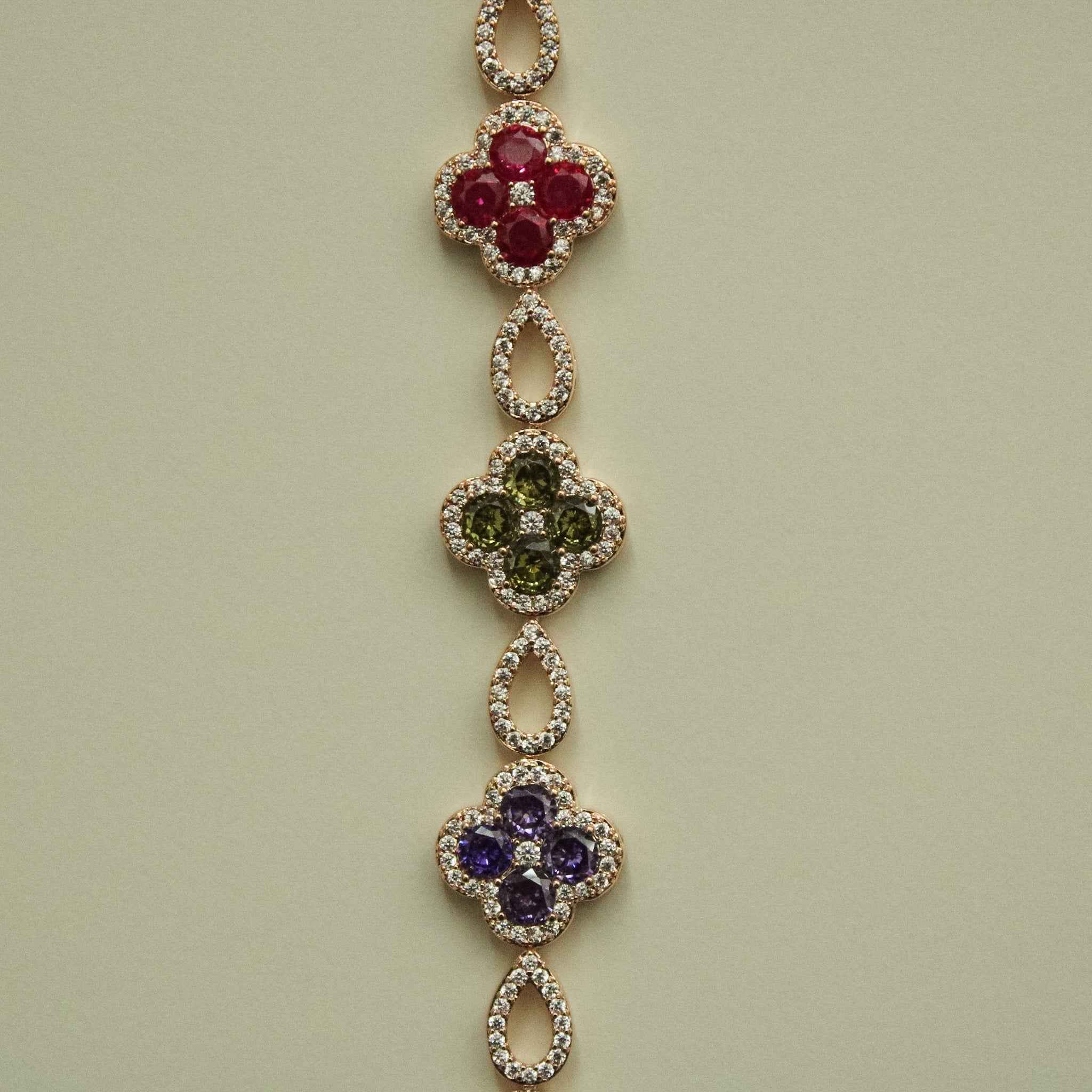 Gold-tone clover CZ bracelet with red, green, purple, and pink charms on a chain