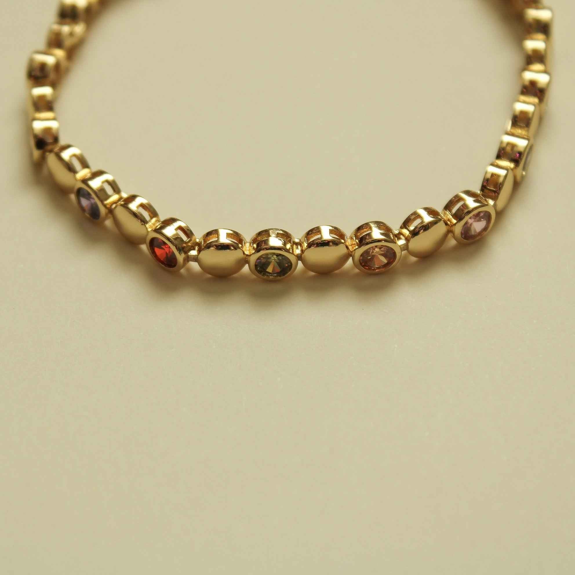 Gold tennis bracelet with multicolor CZ dome stones across scalloped link row