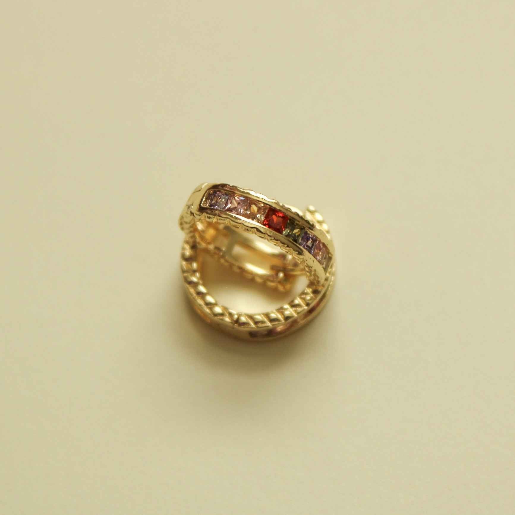 Gold-tone huggie hoop earring with multicolor CZ stones, side view