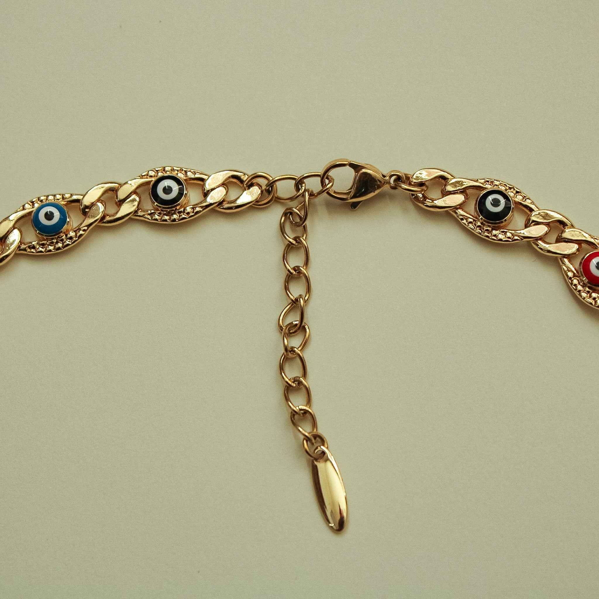 Gold-tone chain necklace with oval evil eye charms and a dangling extender