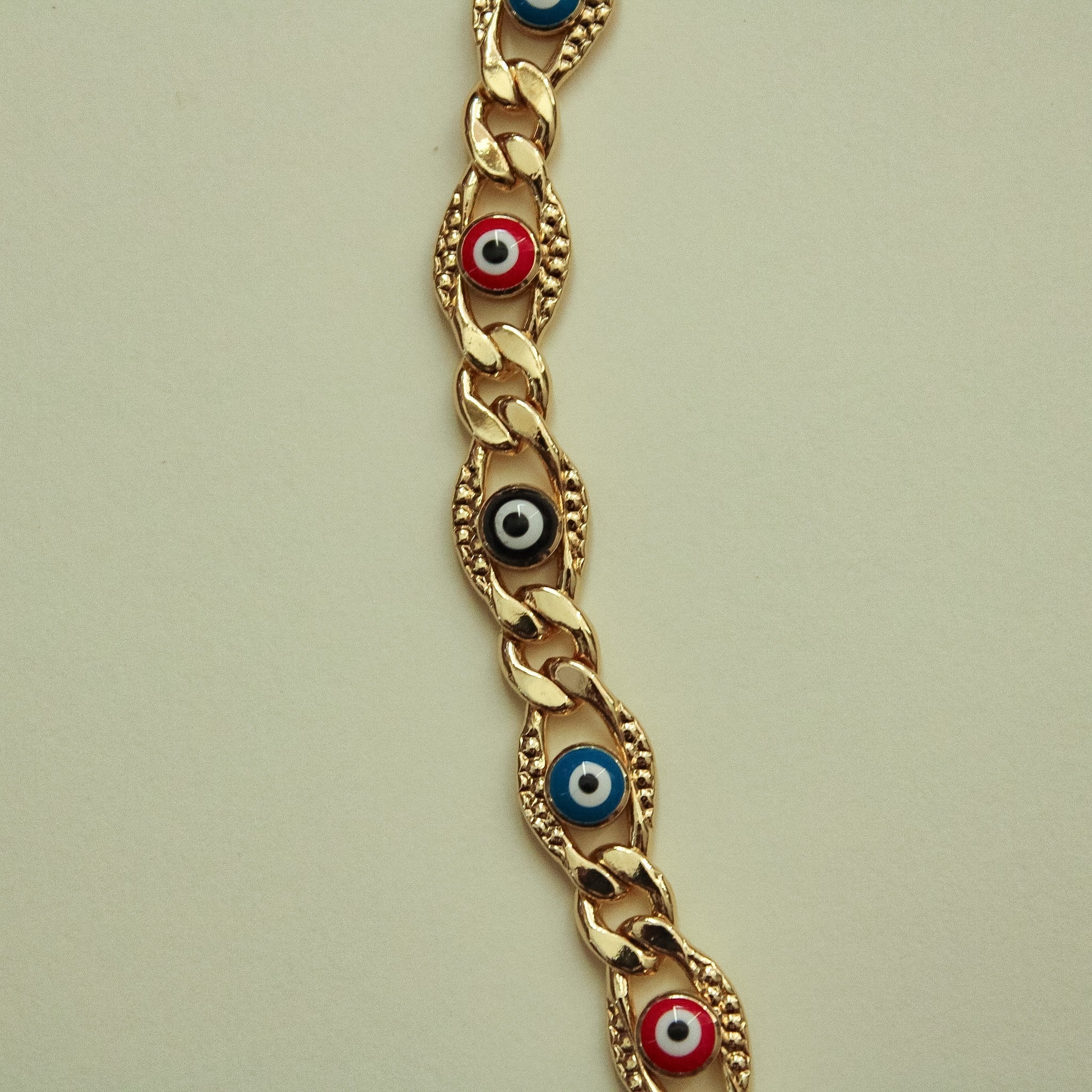 Gold-tone evil eye charm necklace with red, blue, and black eye enamel links