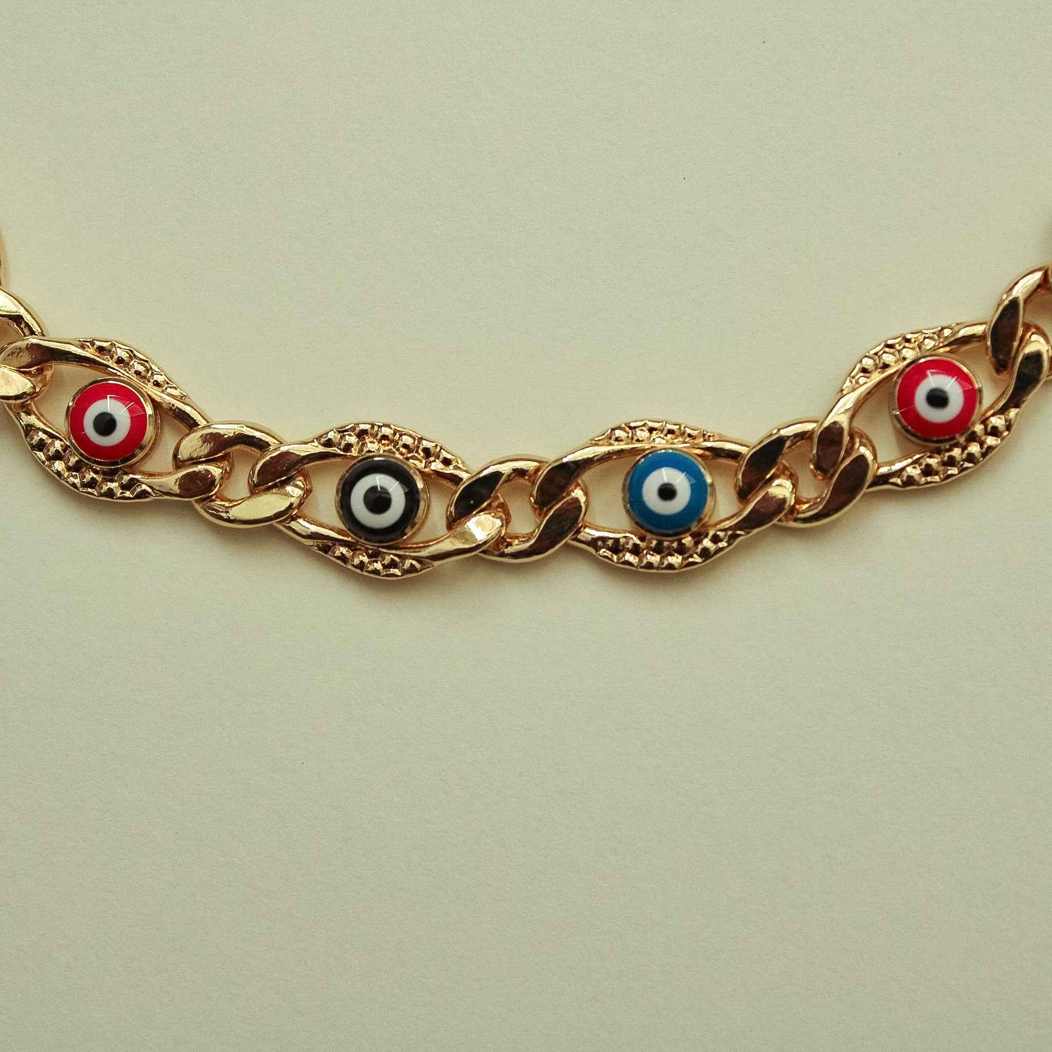 Gold-tone Cuban link necklace with multicolor evil eye charms along the chain