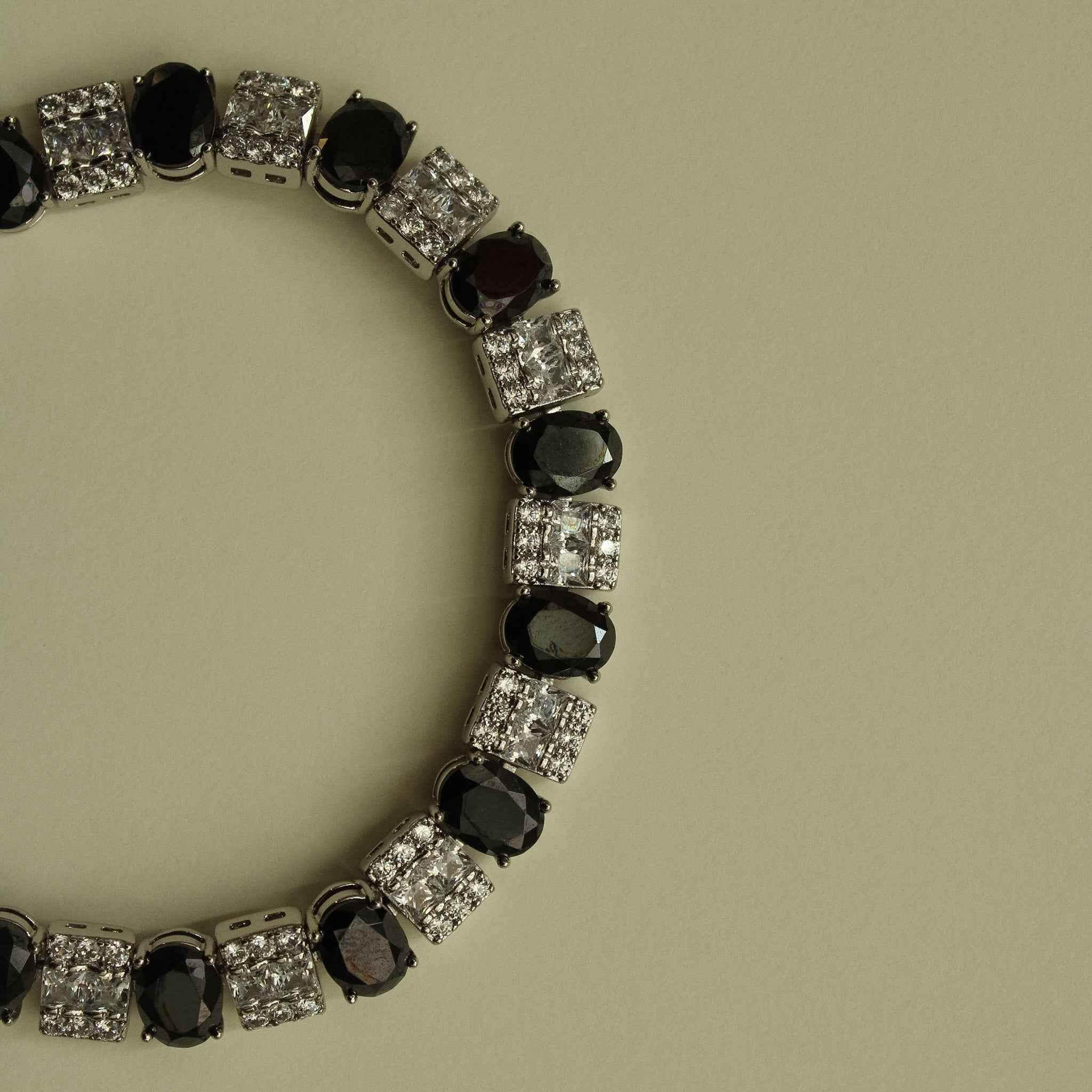 Silver tennis bracelet with black oval stones and clear square CZ links