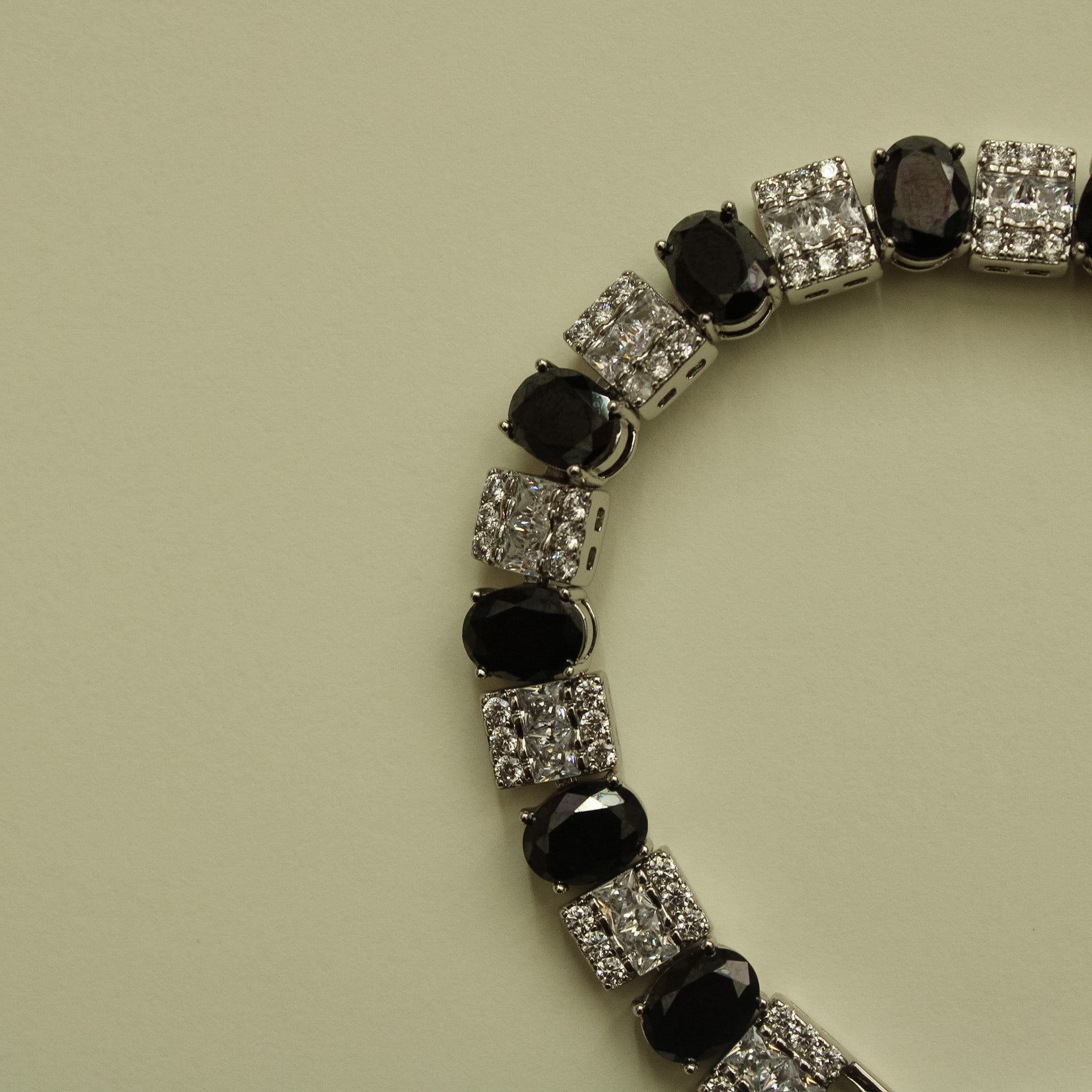 Tennis bracelet with black stones and clear square CZ links in curved row