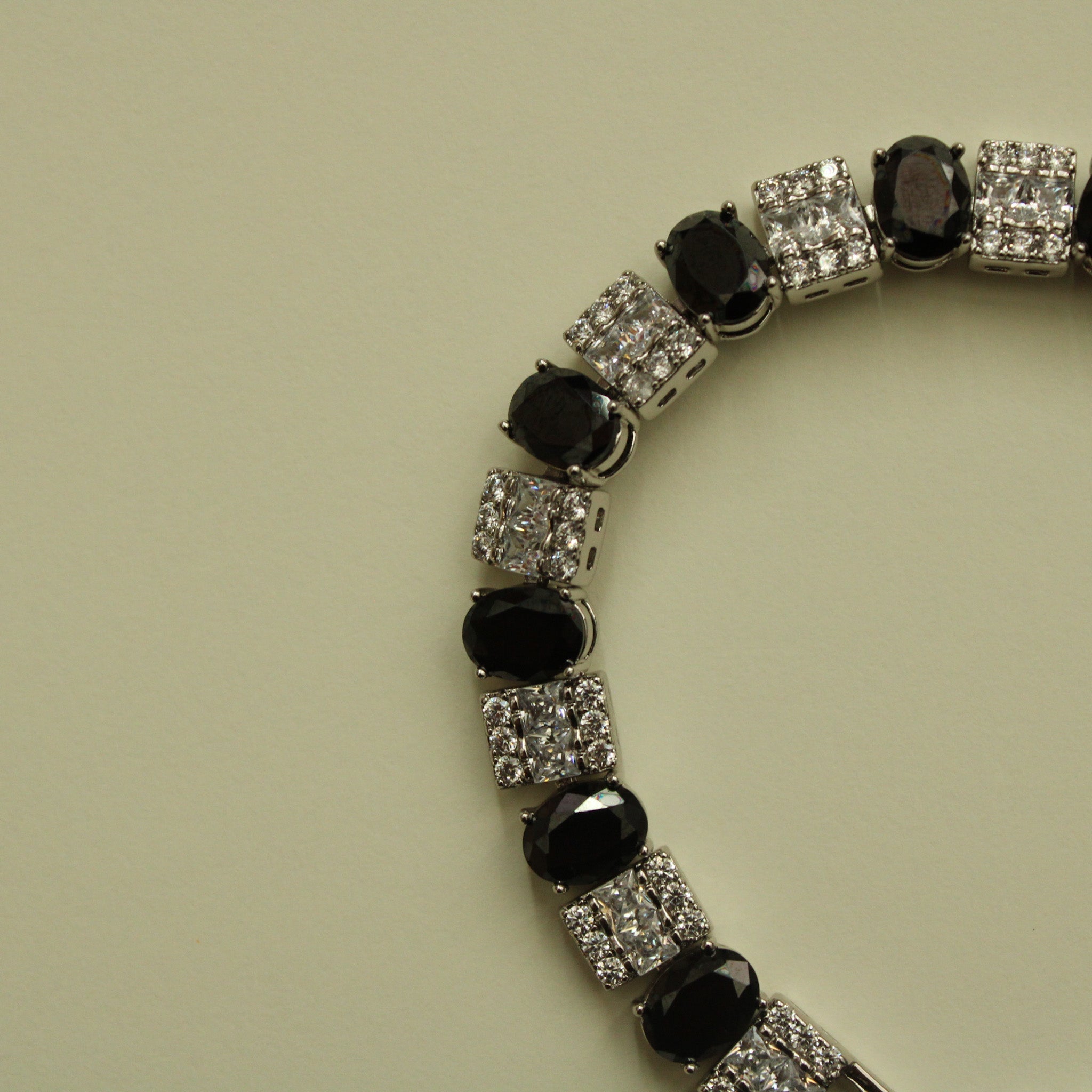 Tennis bracelet angled close-up with black stones and clear square CZ links
