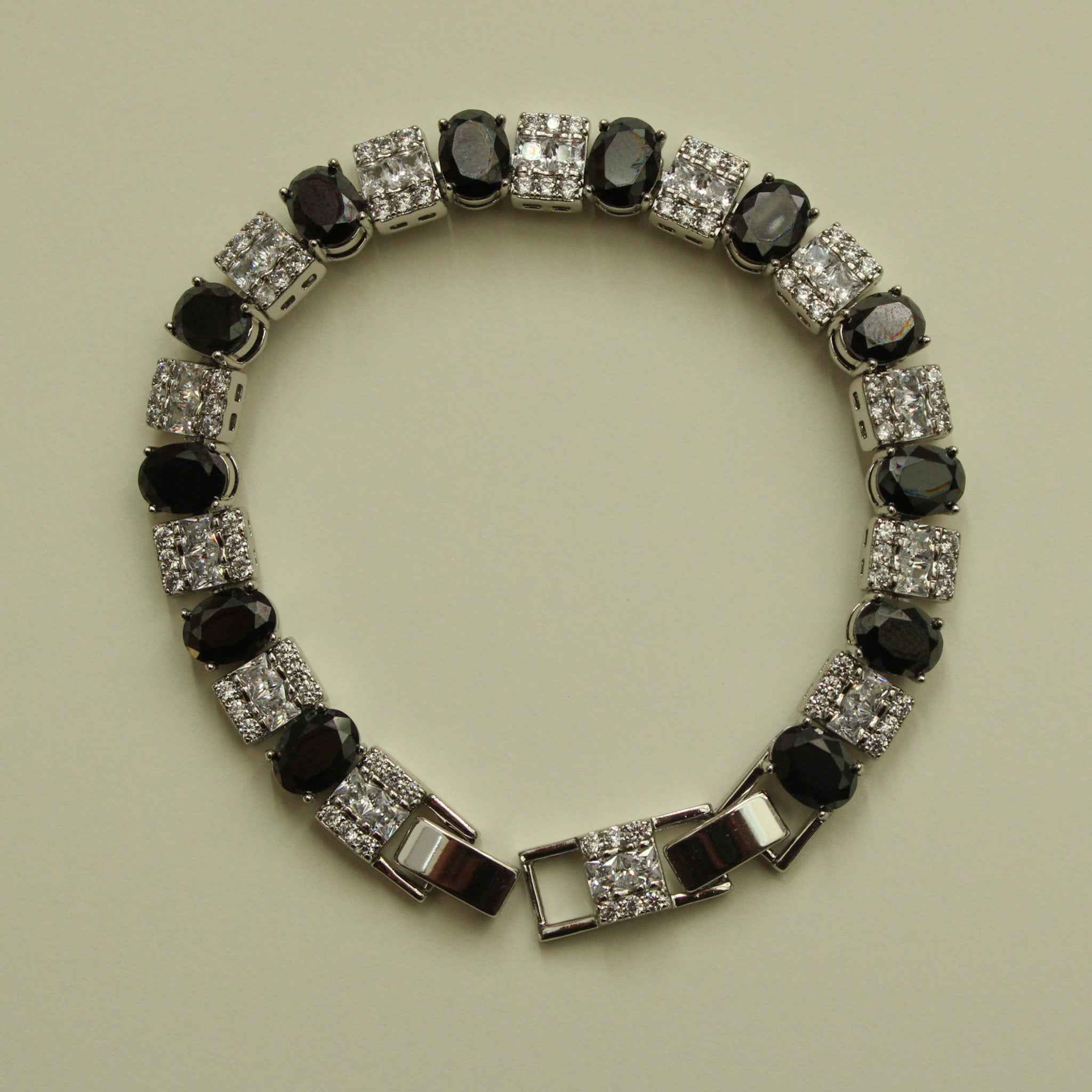 Tennis bracelet front view with black oval stones and clear square CZ links