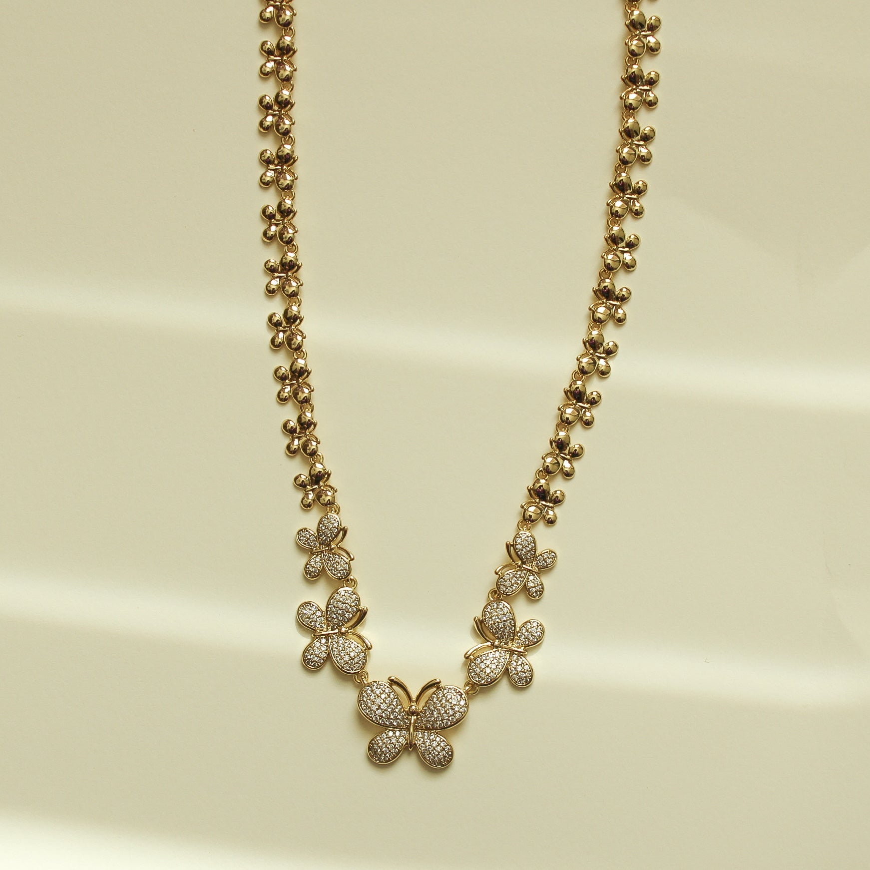 Gold butterfly necklace with clustered pavé stones and ball-bead chain