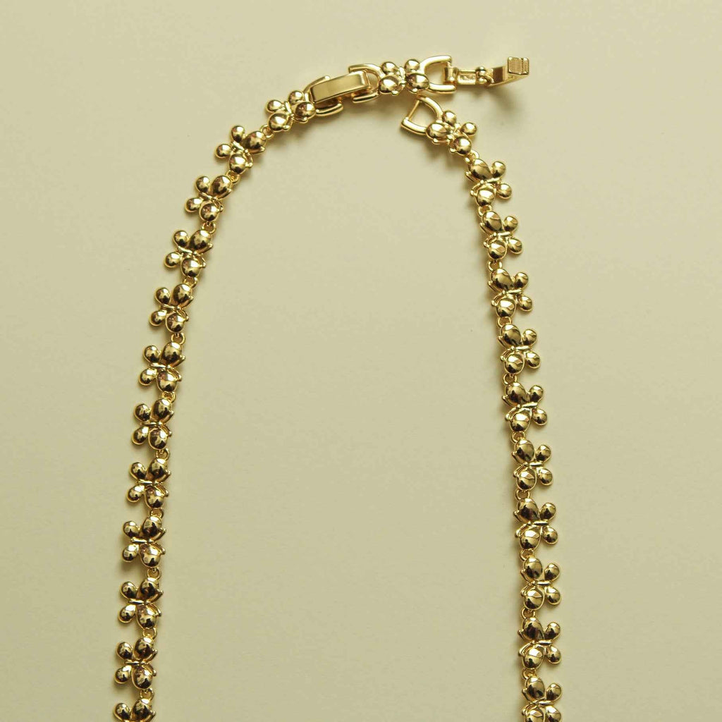 Gold butterfly bracelet with bead chain and clasp, laid out flat