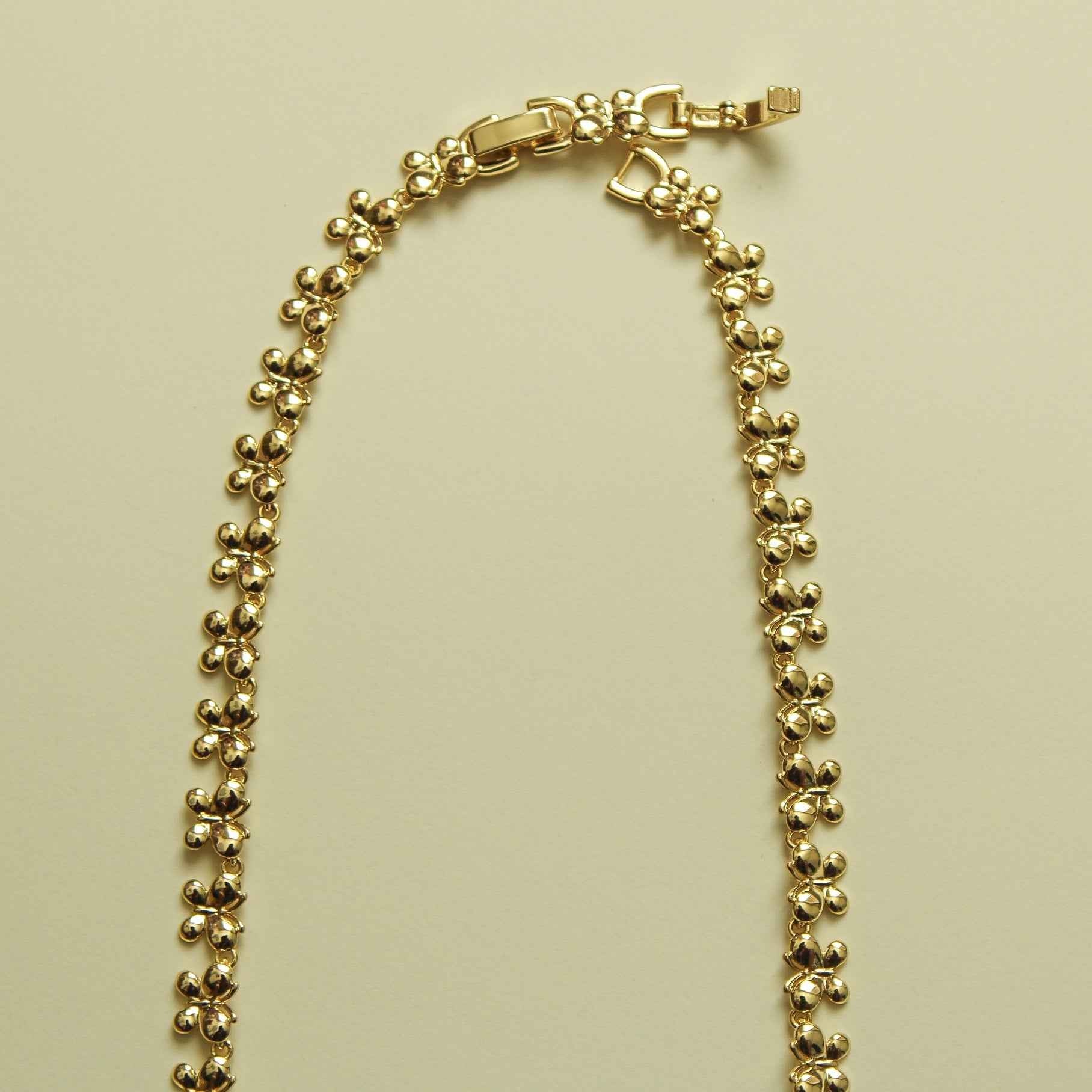 Gold butterfly bracelet with bead chain and clasp, laid out flat