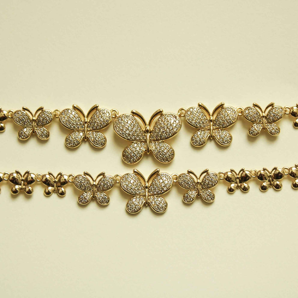 Gold pavé butterfly bracelet with five butterfly charms across two chain rows