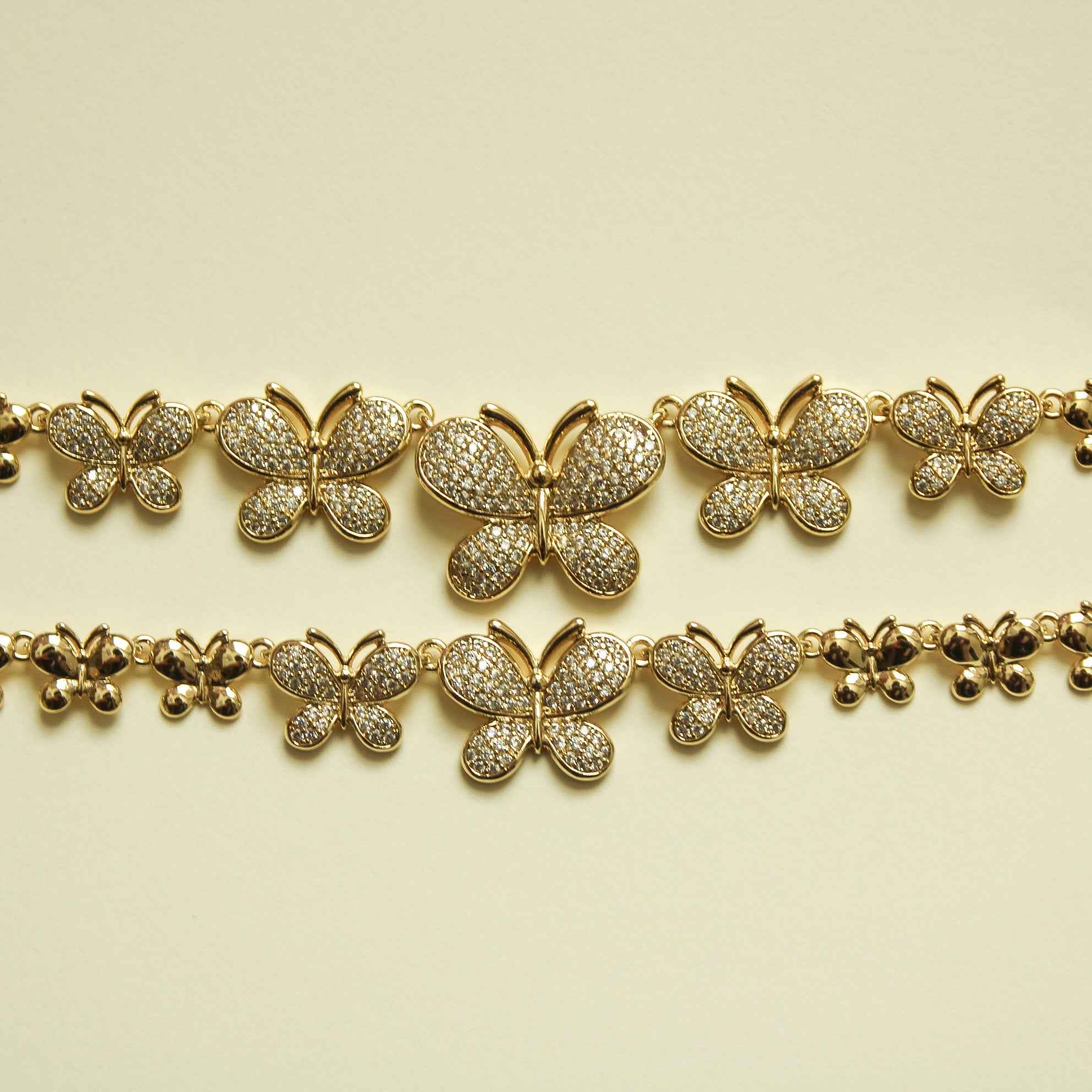 Gold pavé butterfly bracelet with five butterfly charms across two chain rows