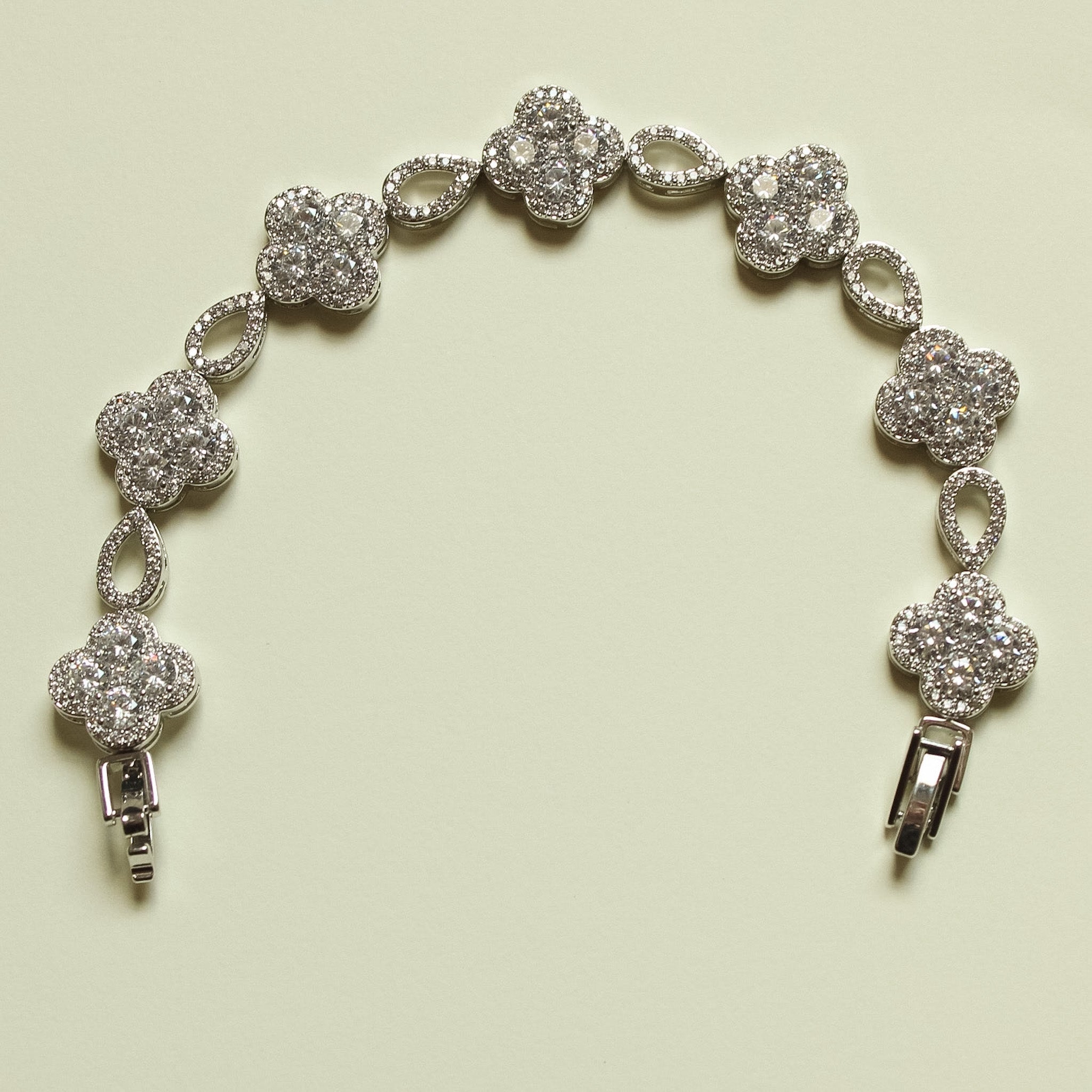 Silver-tone CZ clover bracelet with round clover charms, oval links, and spring clasp