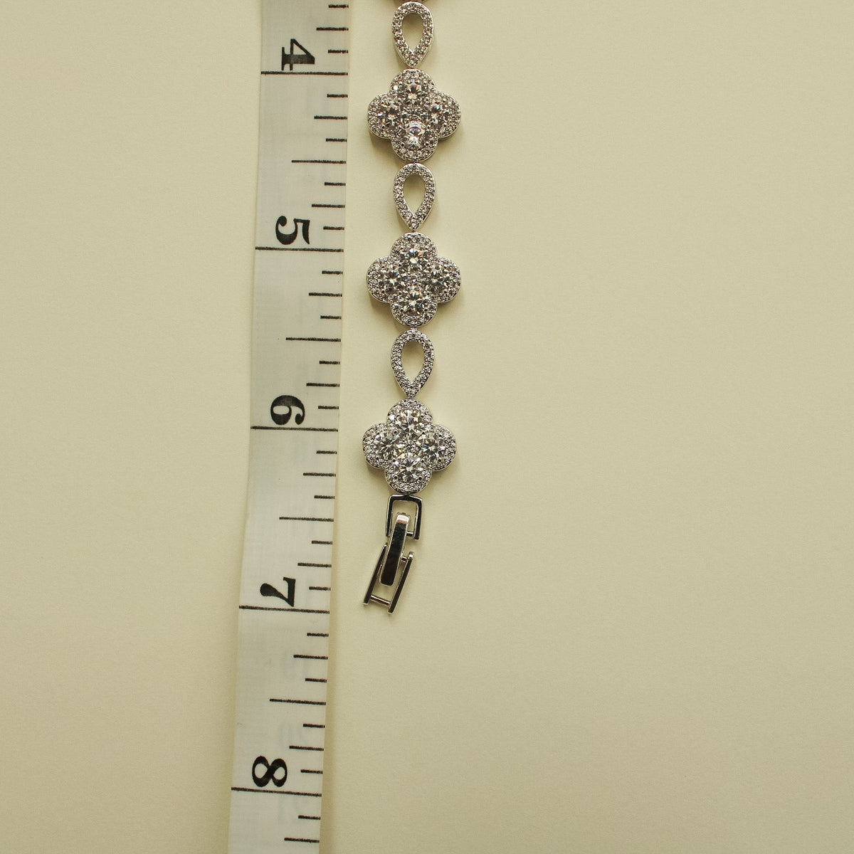CZ clover flower bracelet measured on ruler, showing oval links and clasp