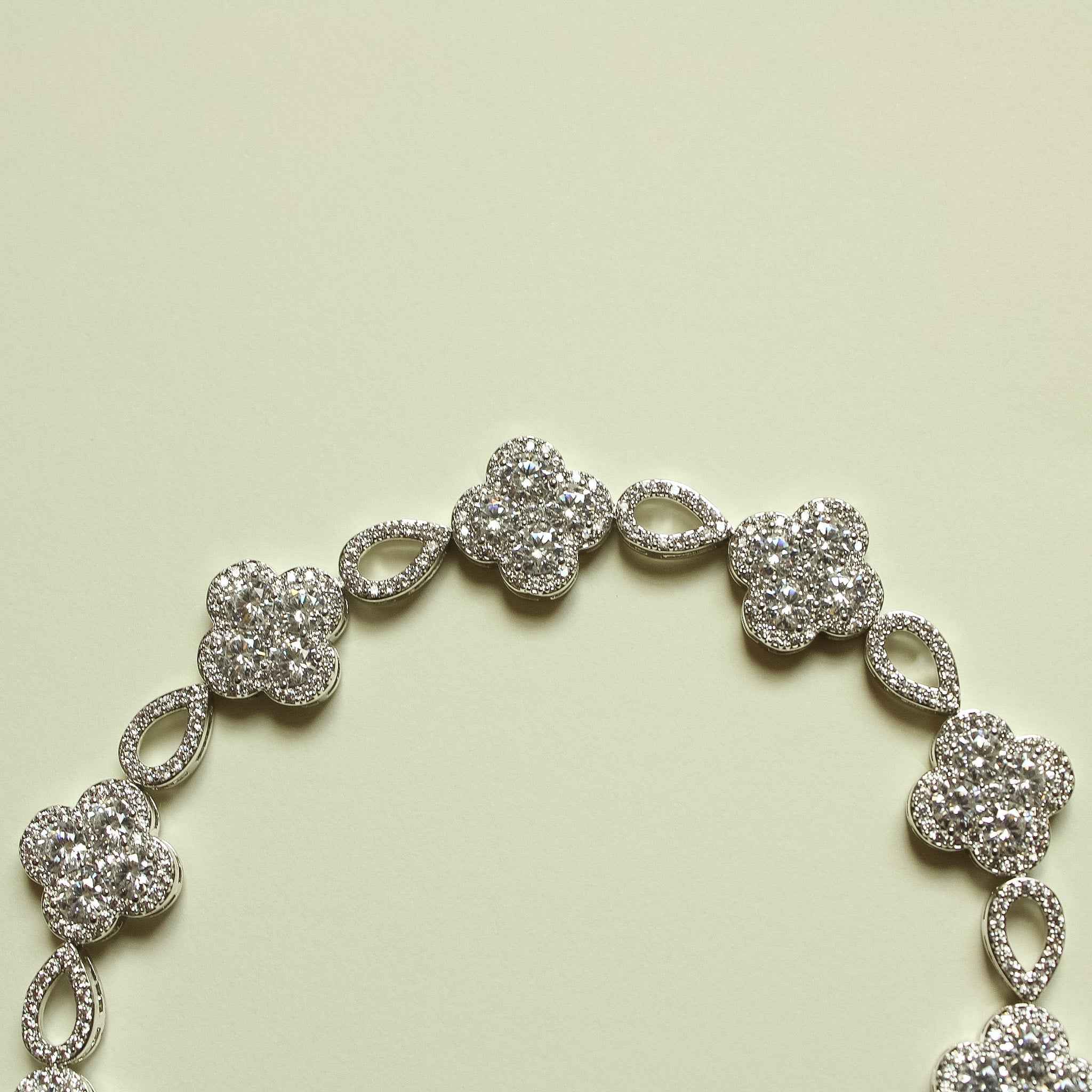 CZ clover flower bracelet with silver-tone links and oval spacer stones
