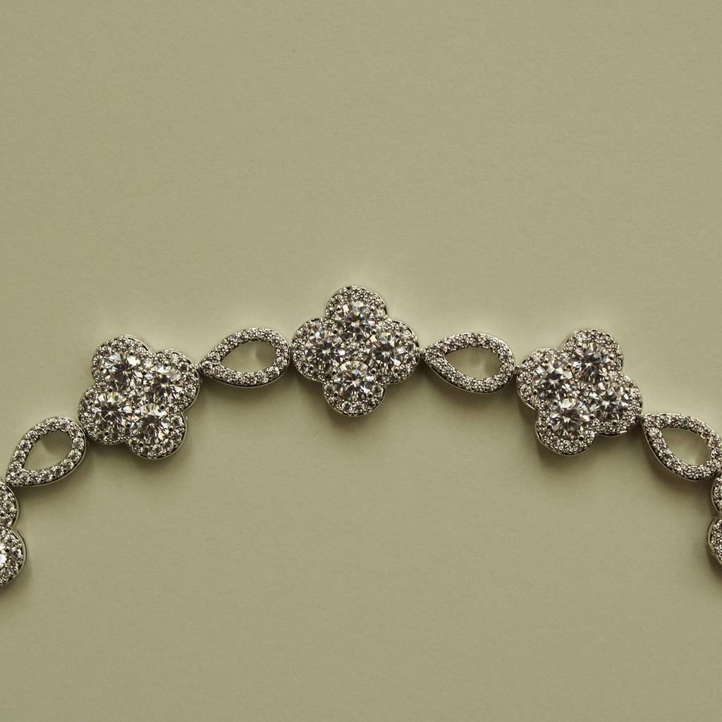 Close-up of silver-tone CZ clover bracelet section with oval spacer links
