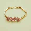 Gold-tone bracelet with five pink and lilac flower gems in a row