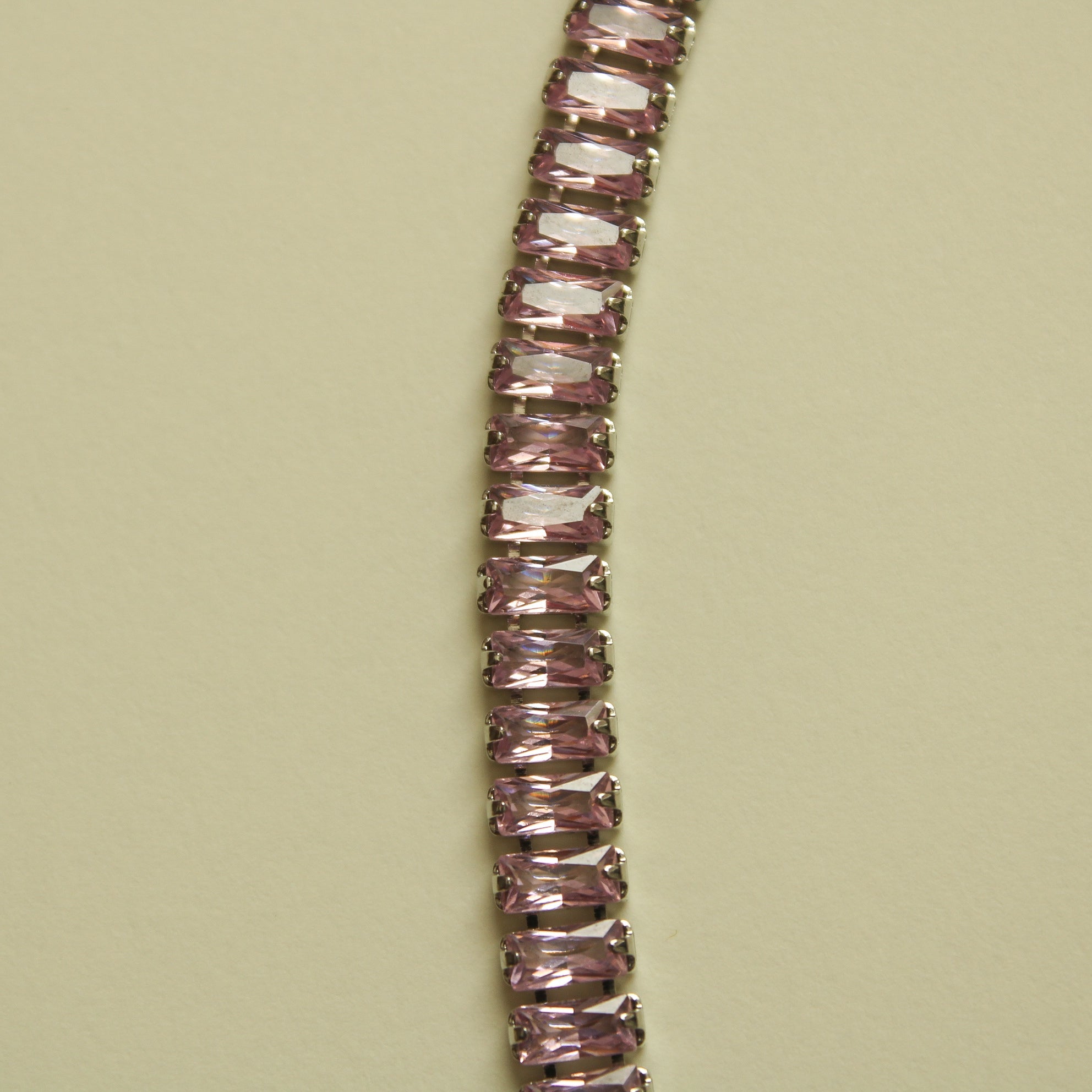 Pink baguette tennis necklace with faceted stones, close-up