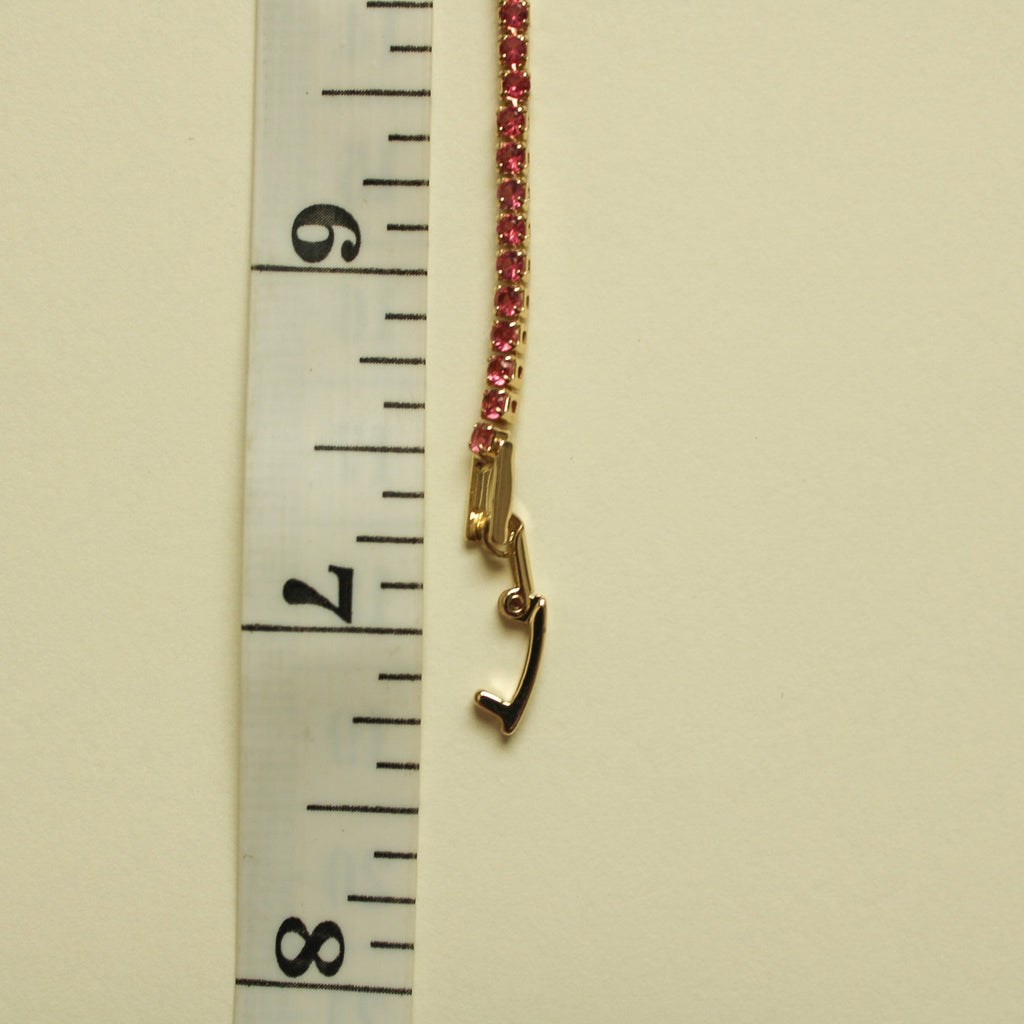 Gold-tone bracelet with a pink CZ row and small clasp hook at the end.