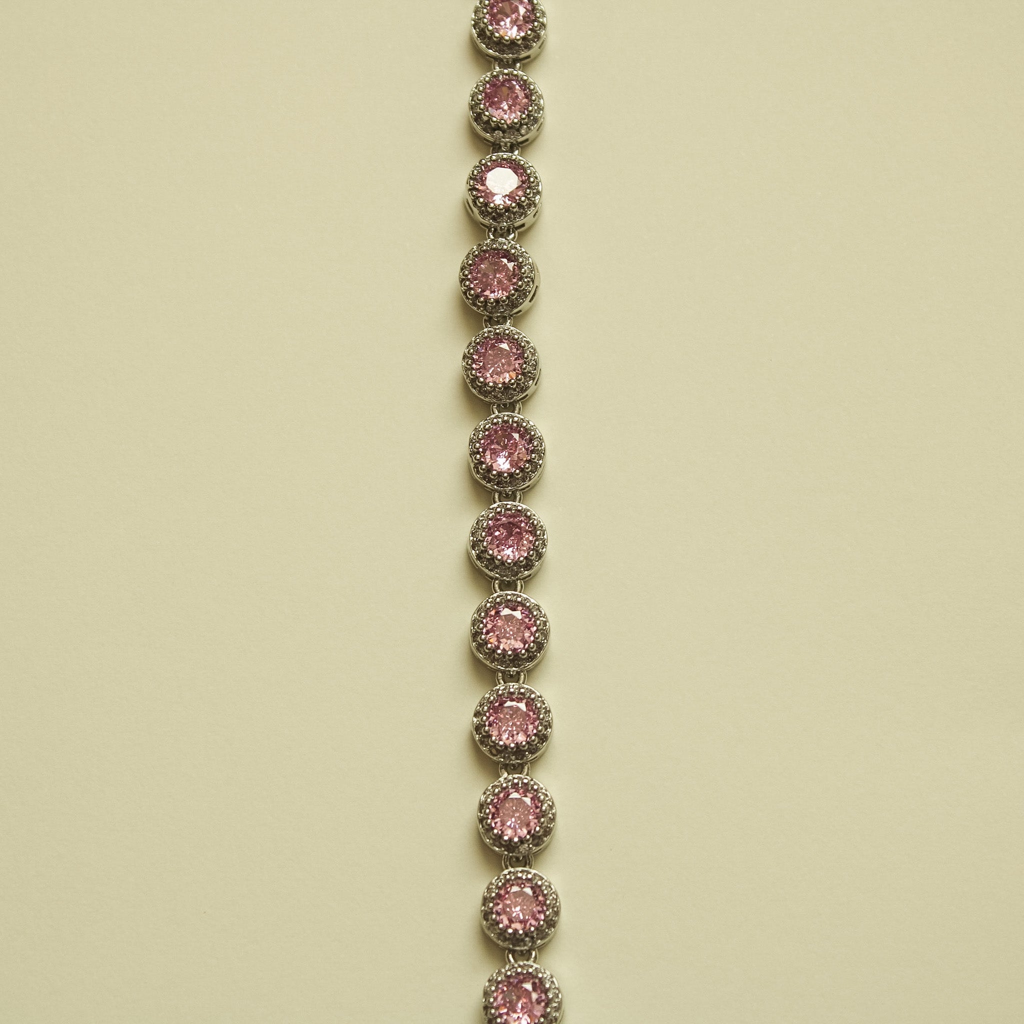 Pink halo CZ tennis bracelet, vertical view of linked round bezel-set stones