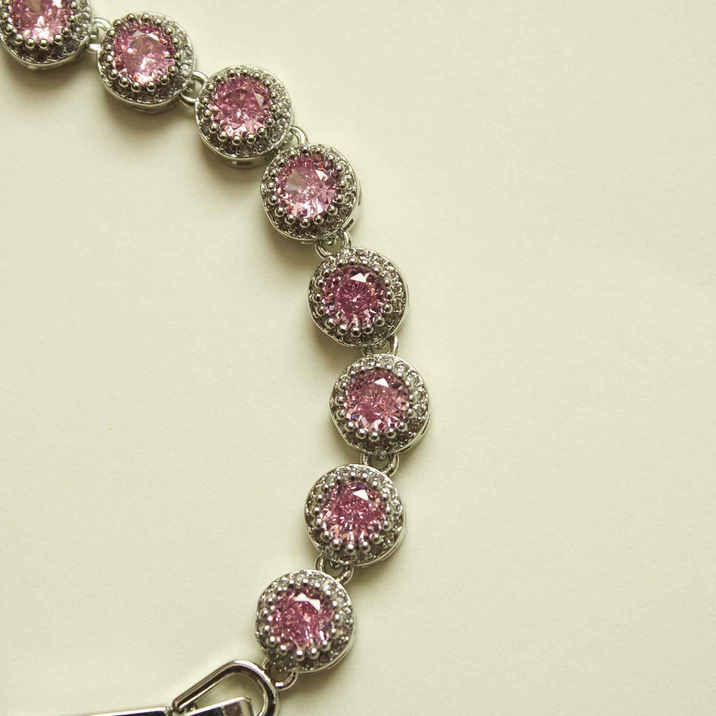 Pink halo CZ tennis bracelet strand with evenly spaced round stones and open clasp