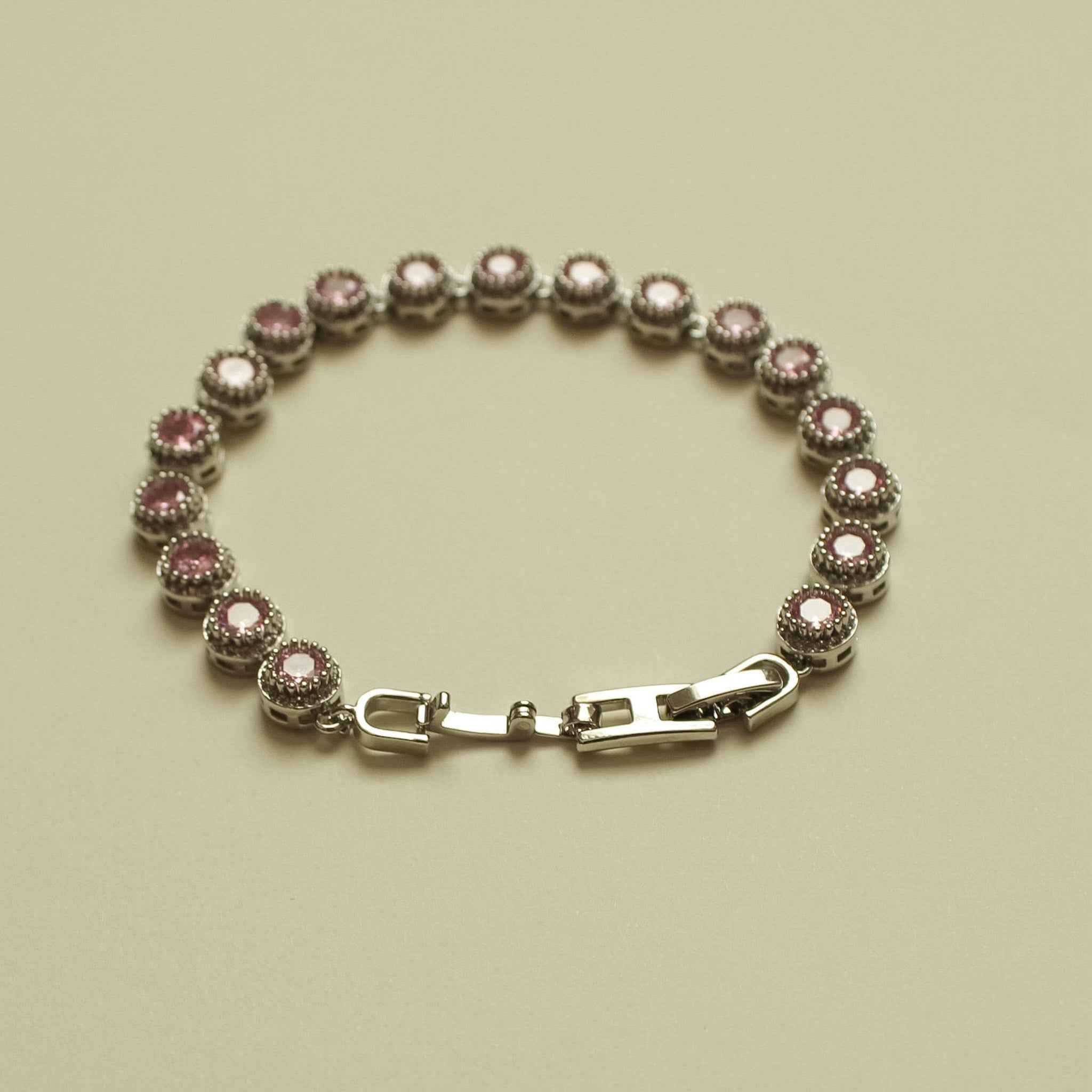 Pink halo CZ tennis bracelet with round pink stones and silver-tone clasp