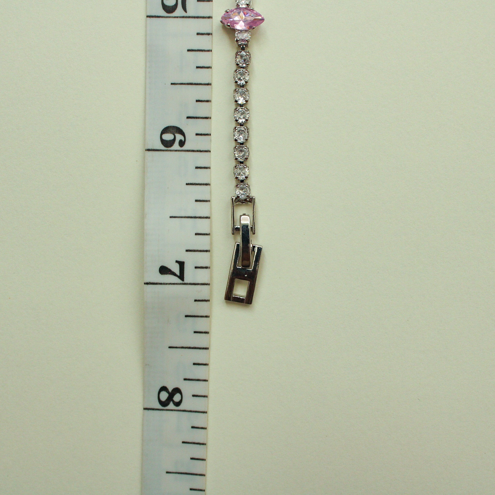 Pink marquise and clear CZ tennis bracelet shown with box clasp, side view