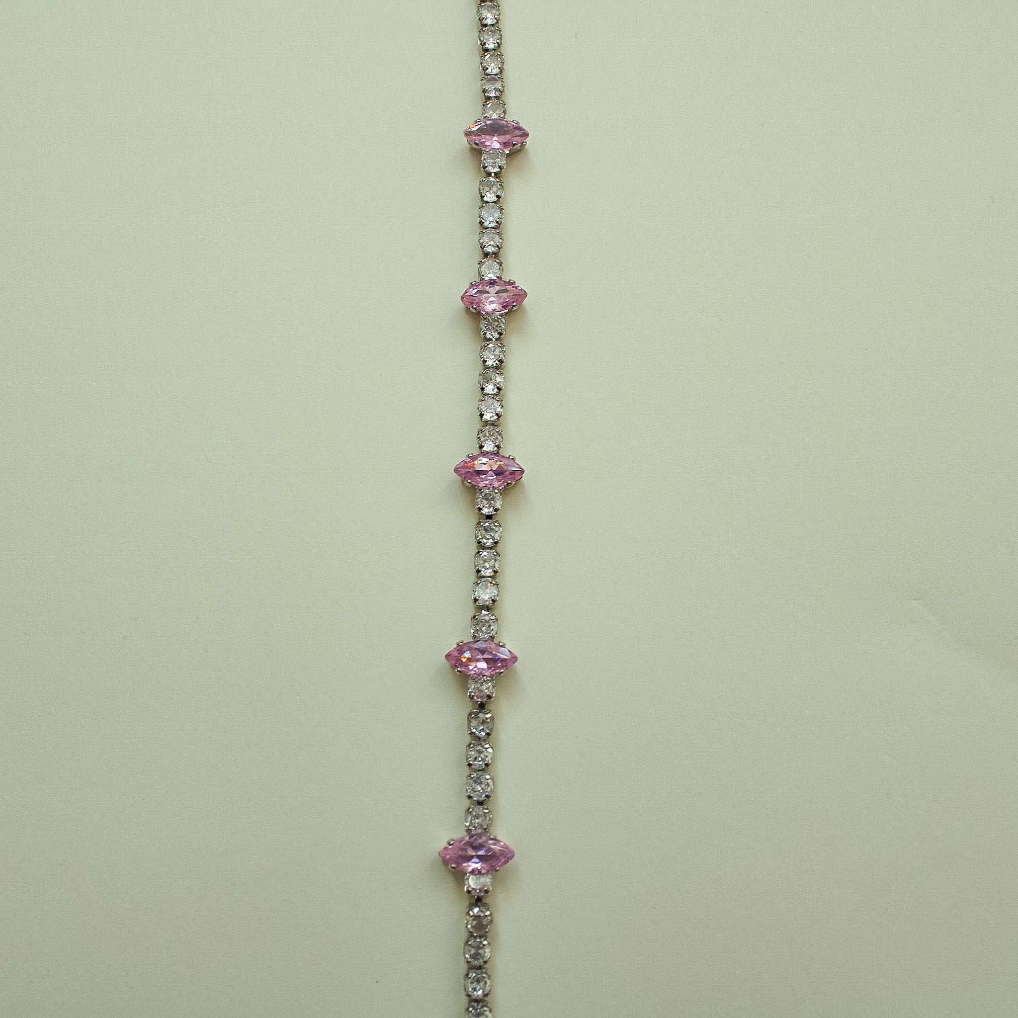 Pink marquise CZ tennis bracelet with repeating pink stones along a pavé band