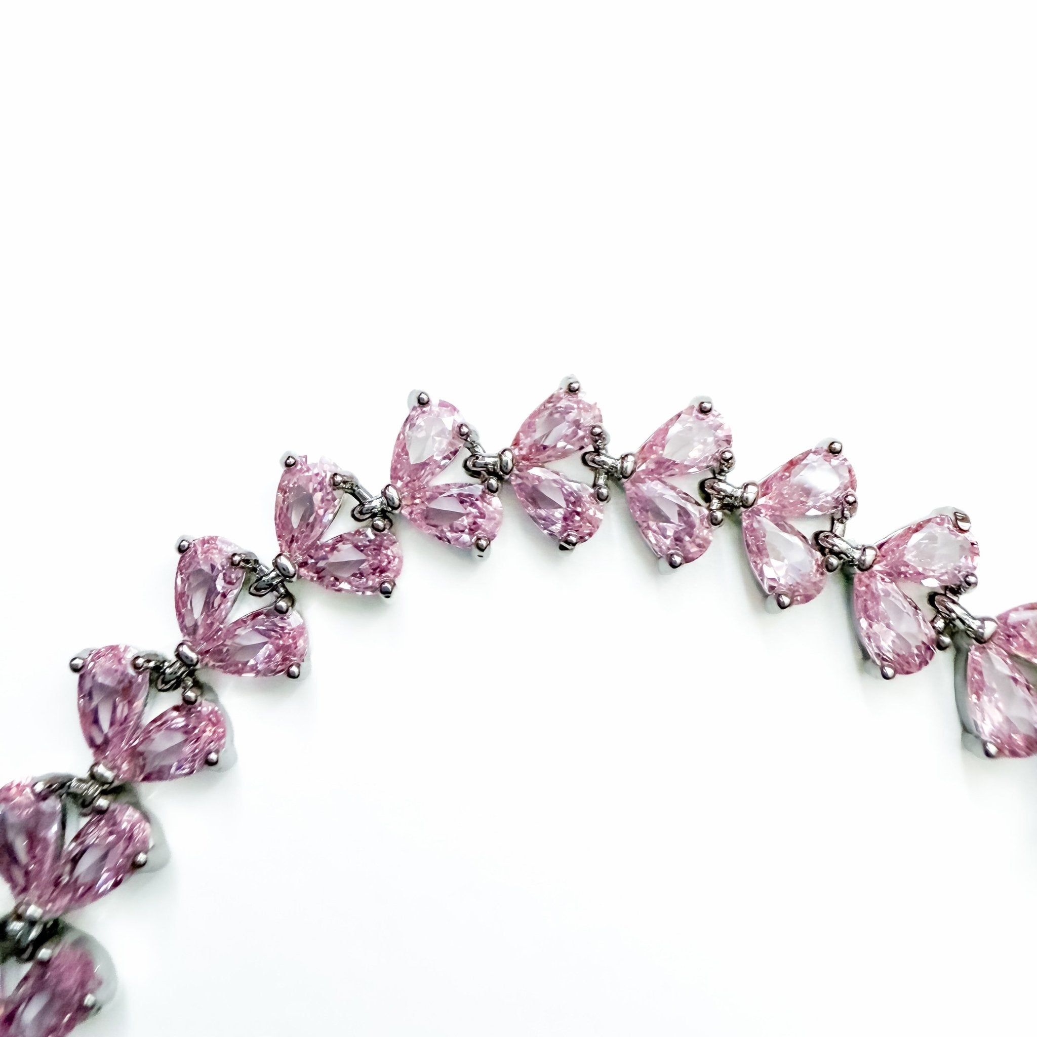 Pink CZ tennis bracelet detail view of pear-shaped pink stones in silver prong settings