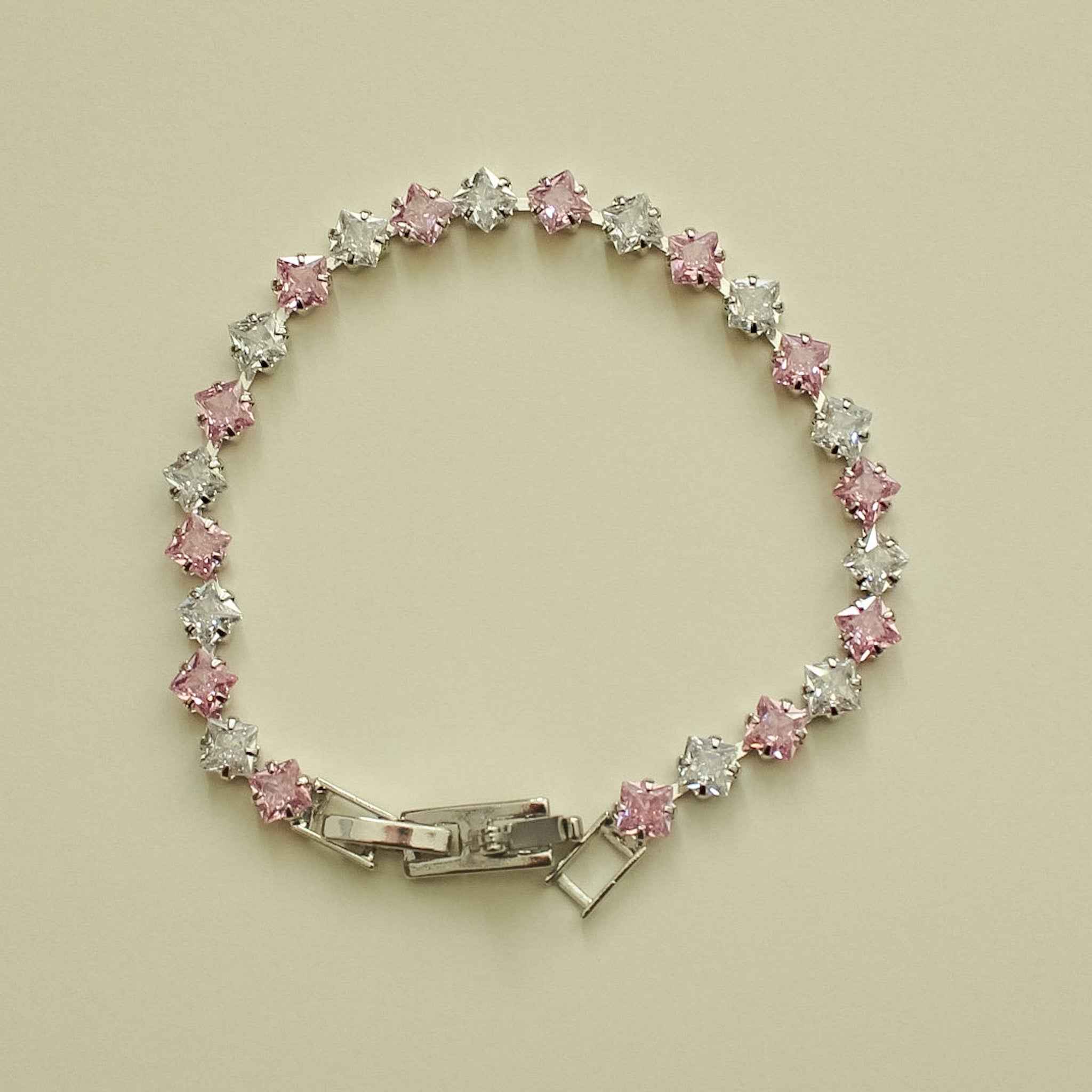 Tennis bracelet with pink and clear princess-cut CZ stones in round bezel settings