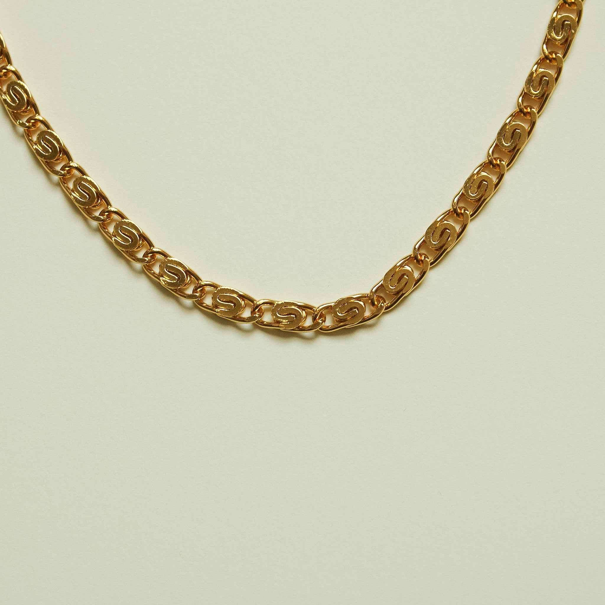 Gold S-link chain necklace close-up of interlocking links