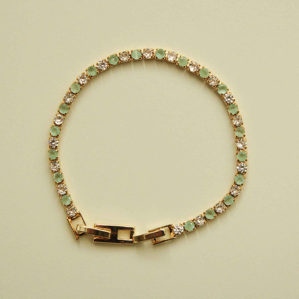 Gold-tone tennis bracelet with seafoam green stones, clear CZ accents, hinged clasp