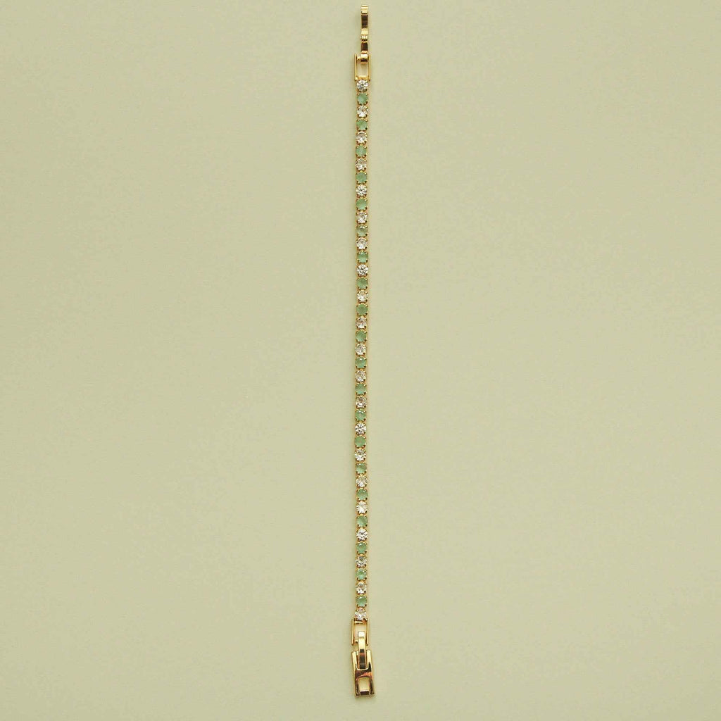 Gold-tone tennis bracelet with a straight row of seafoam green stones and CZs