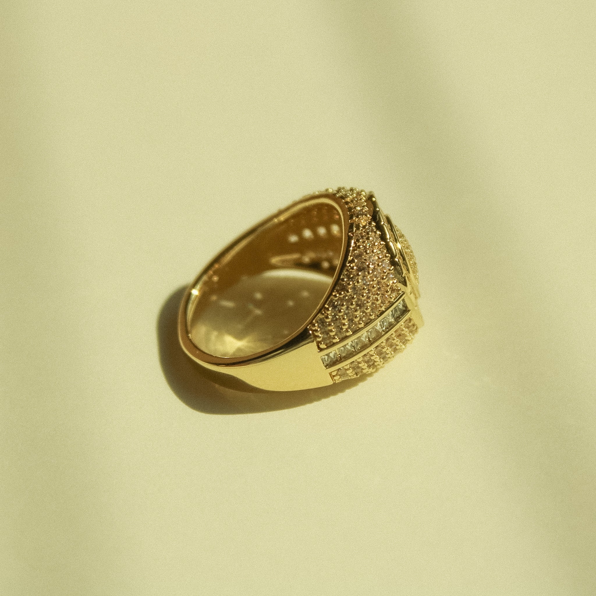 Gold-tone signet ring showing side profile with pavé CZ band across the top