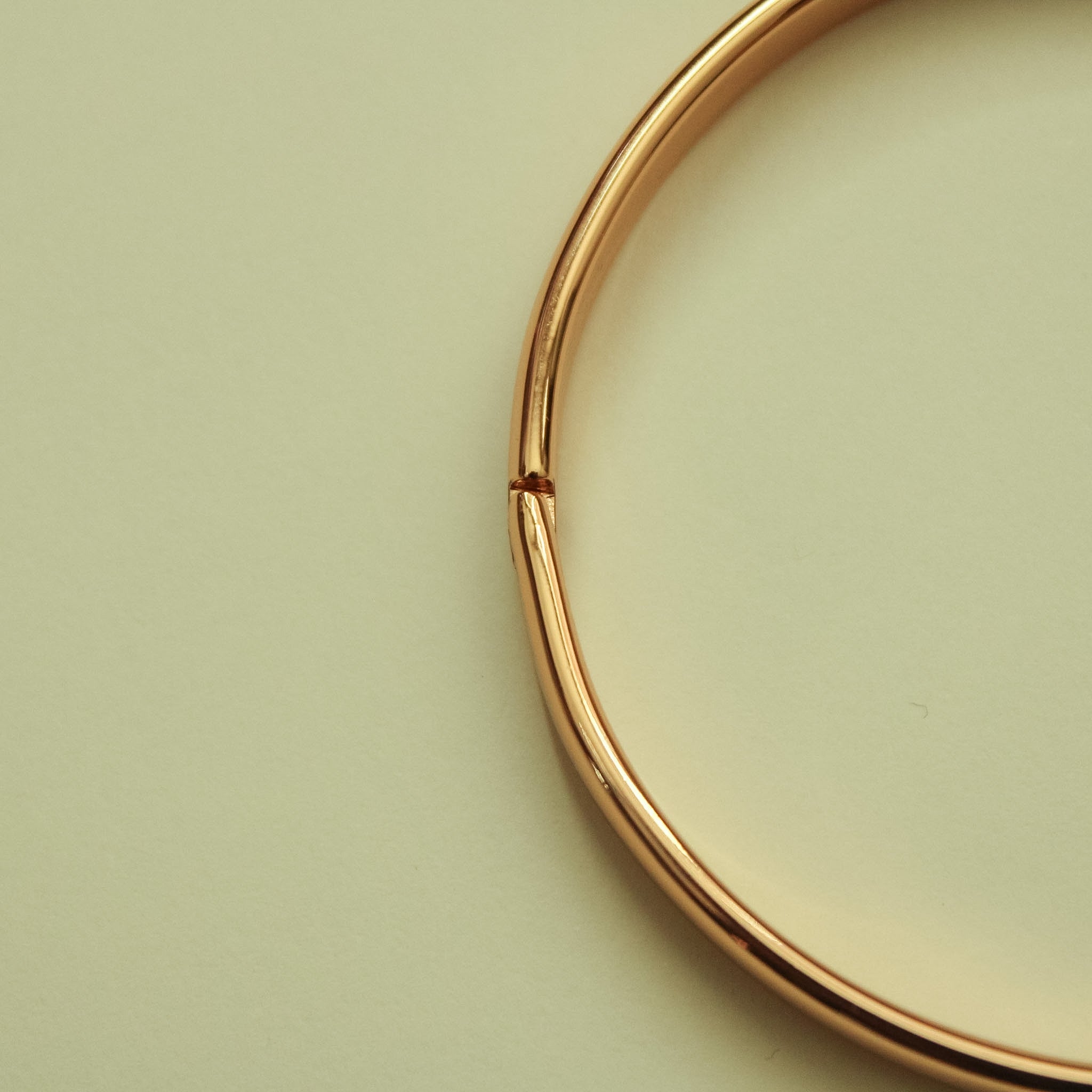 Rose gold bangle side view, smooth band with small opening