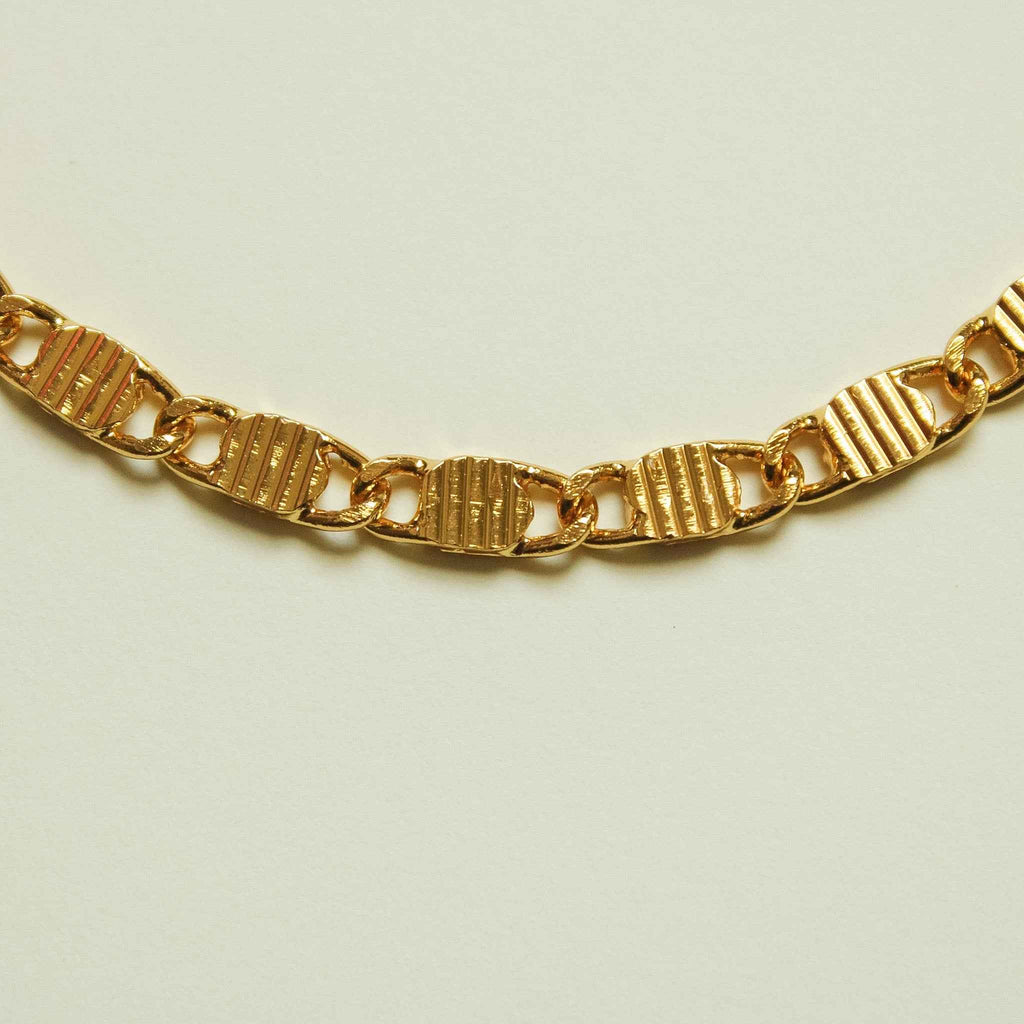 Textured link chain necklace with gold-tone striped links and clasp detail
