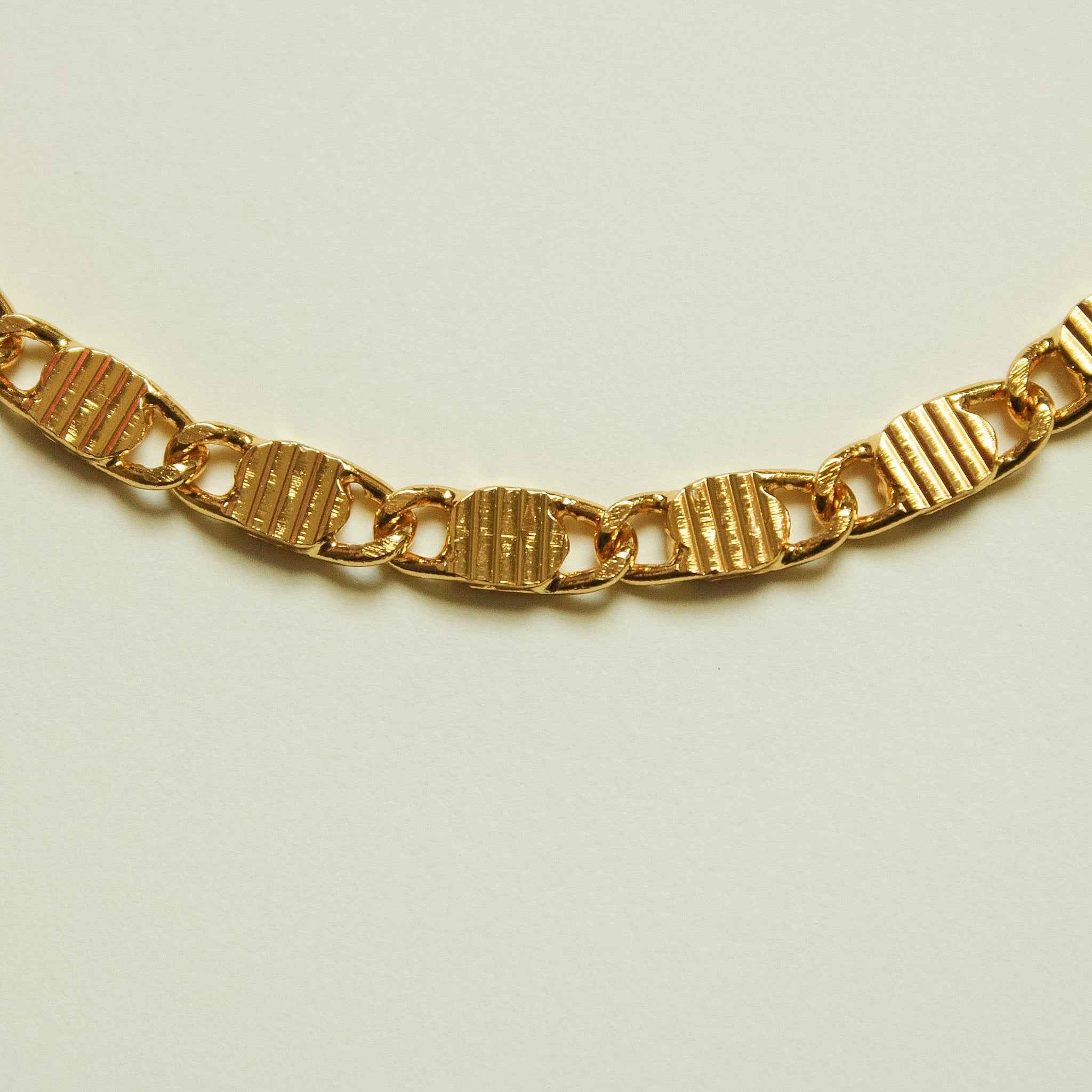 Textured link chain necklace with gold-tone striped links and clasp detail