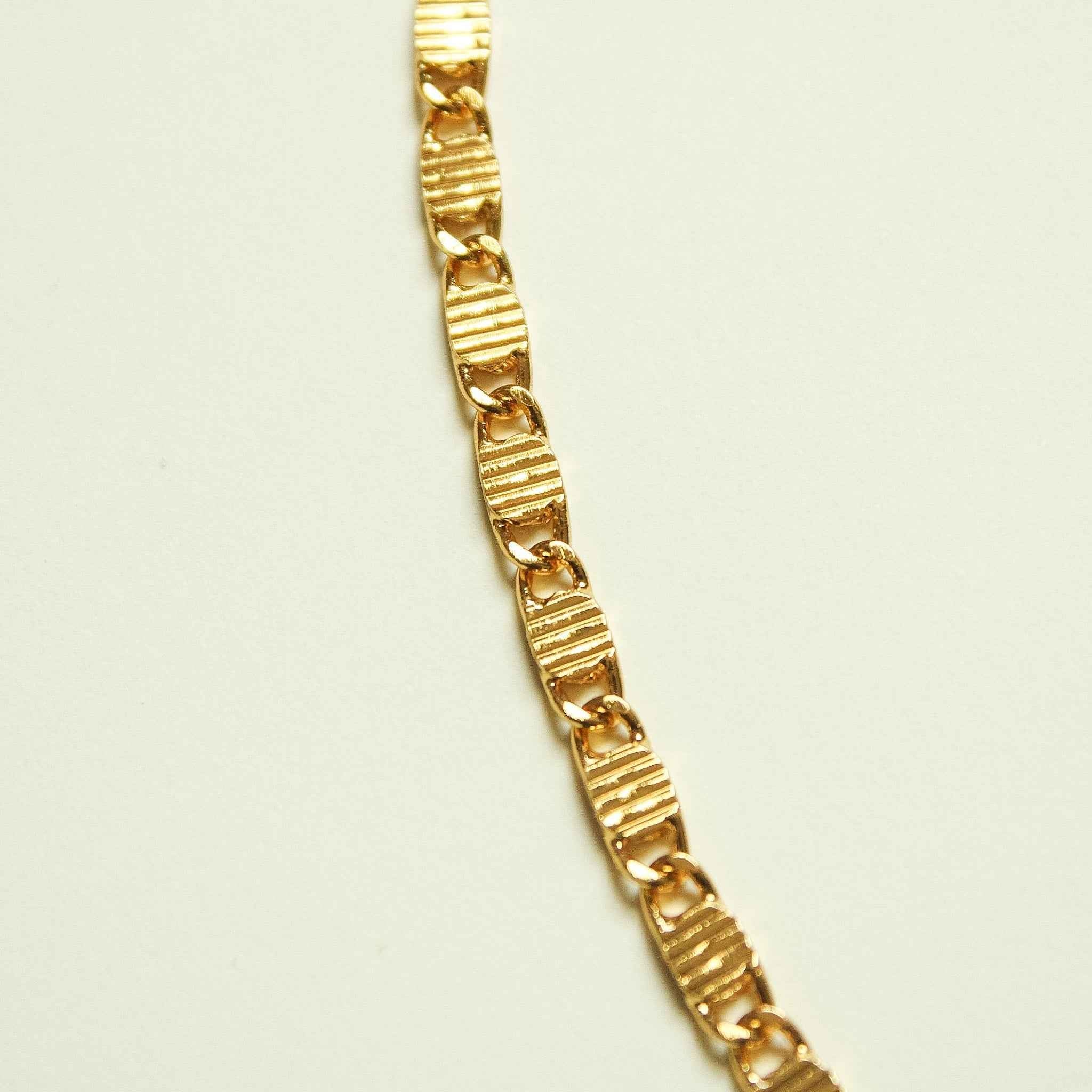 Gold-tone textured link chain necklace, close-up of striped links