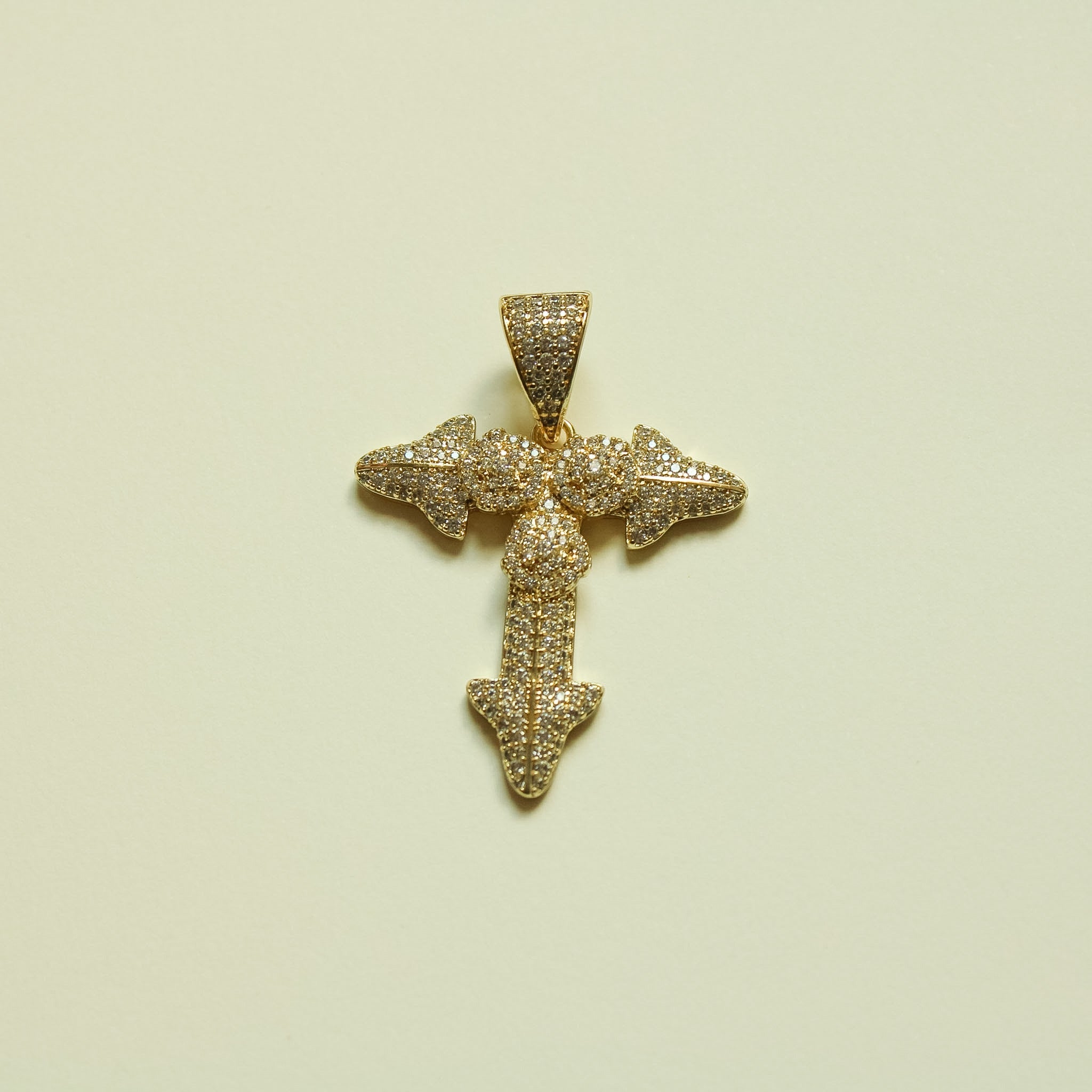 Gold-tone crystal-studded cross pendant with round center and three pointed arms