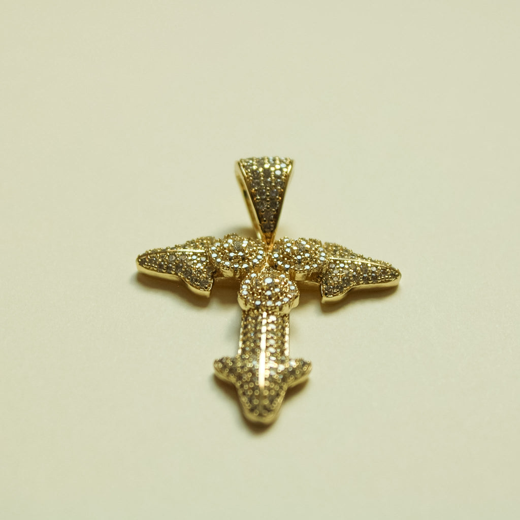 Gold-tone rhinestone cross pendant with small round center and arrow-shaped bottom