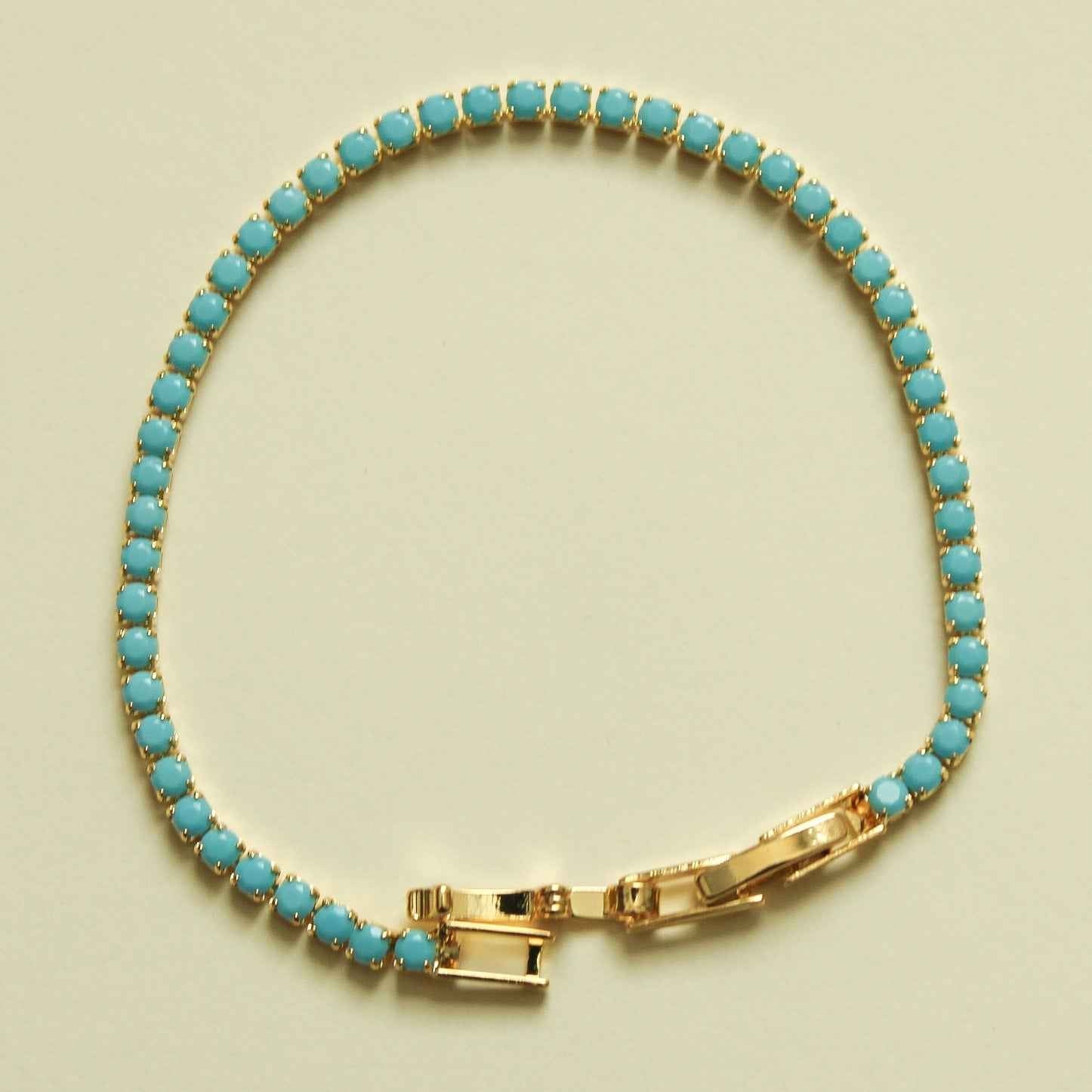 Turquoise beaded tennis bracelet with gold bar clasp and turquoise oval stones