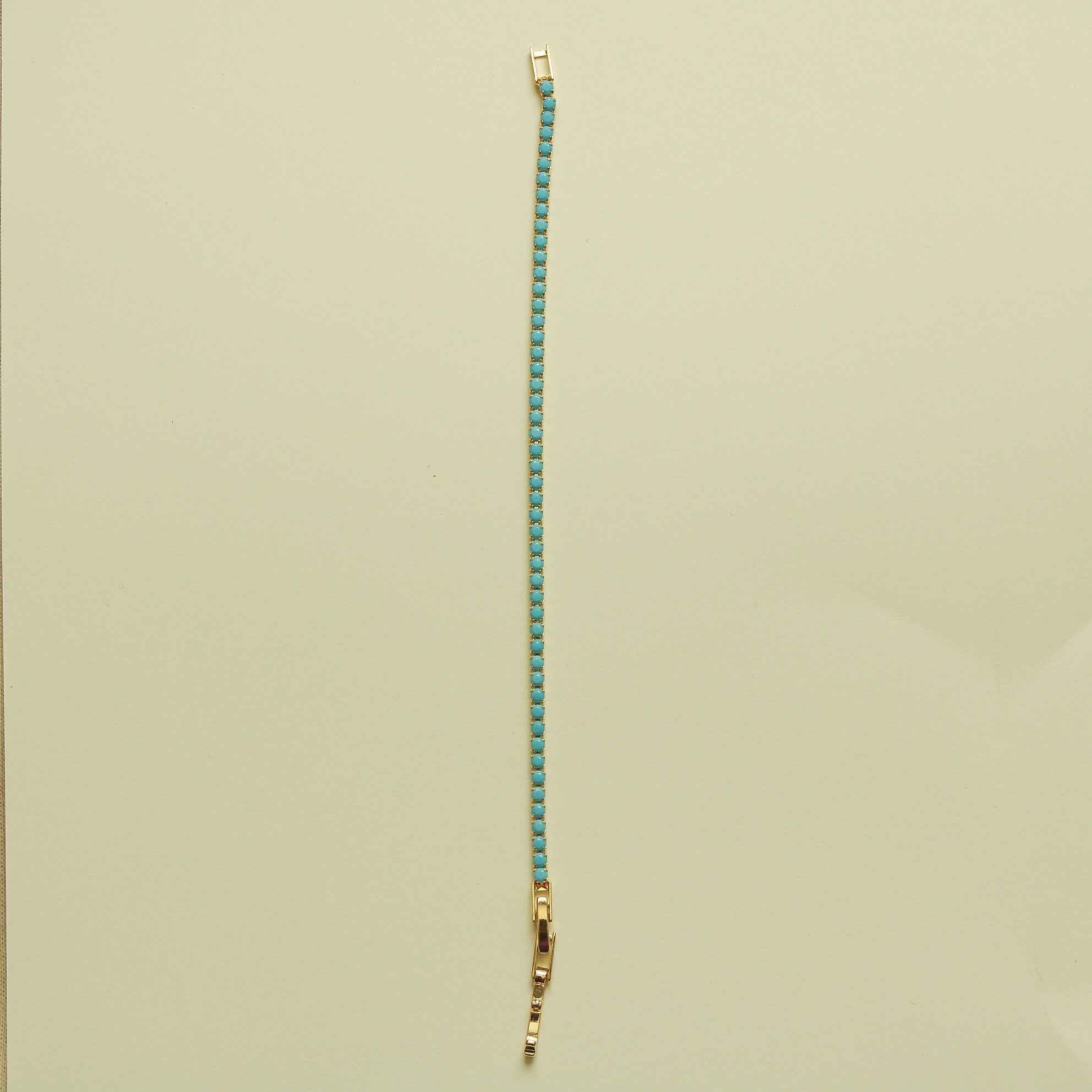Turquoise beaded tennis bracelet with gold end caps and bead-lined chain